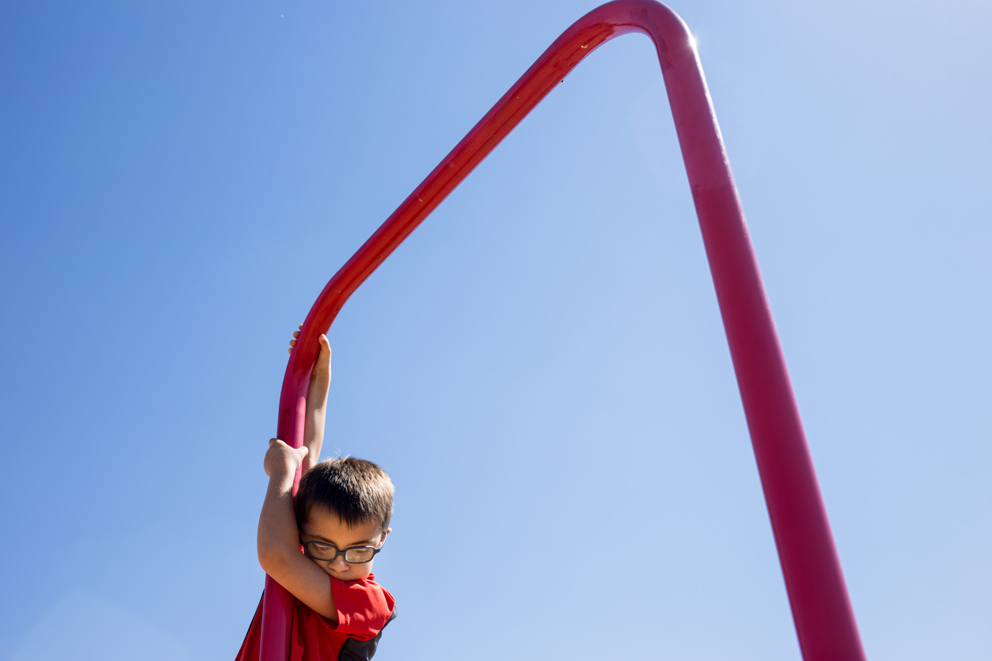  Treven hangs from the monkey bars on the playground at Perryville Elementary during recess on Wednesday. Because he has Down’s syndrome, Treven is developmentally behind other kids his age. 
