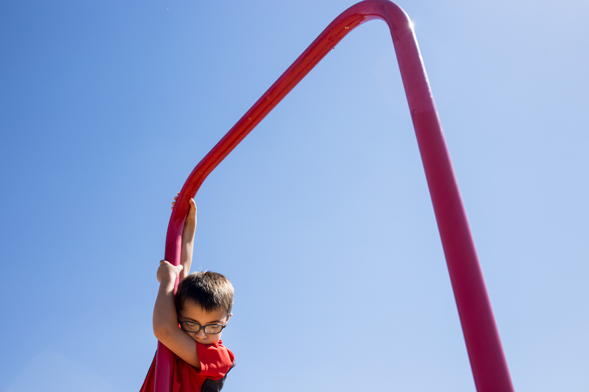 Treven hangs from the monkey bars on the playground at Perryville Elementary during recess on Wednesday. Because he has Down’s syndrome, Treven is developmentally behind other kids his age.