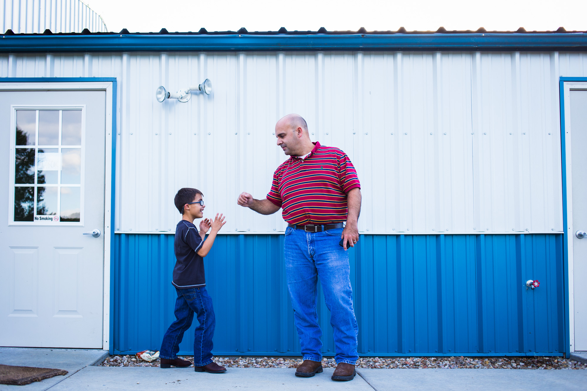  Treven and his father, Andy Comstock, wait outside the equestrian center for Treven’s horse therapy session. Andy admits he has different views about how to raise Treven: “to me, I see him and think I can make him into a man. But for Bettina, he’s s