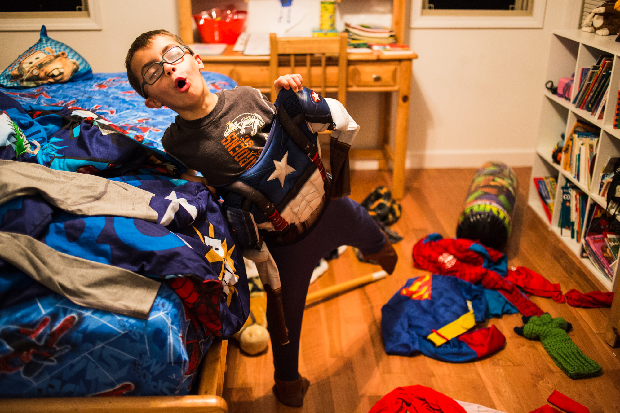  Treven tries on one of his many superhero costumes in his bedroom. Like other kids his age, he loves cartoons and superhero movies. 