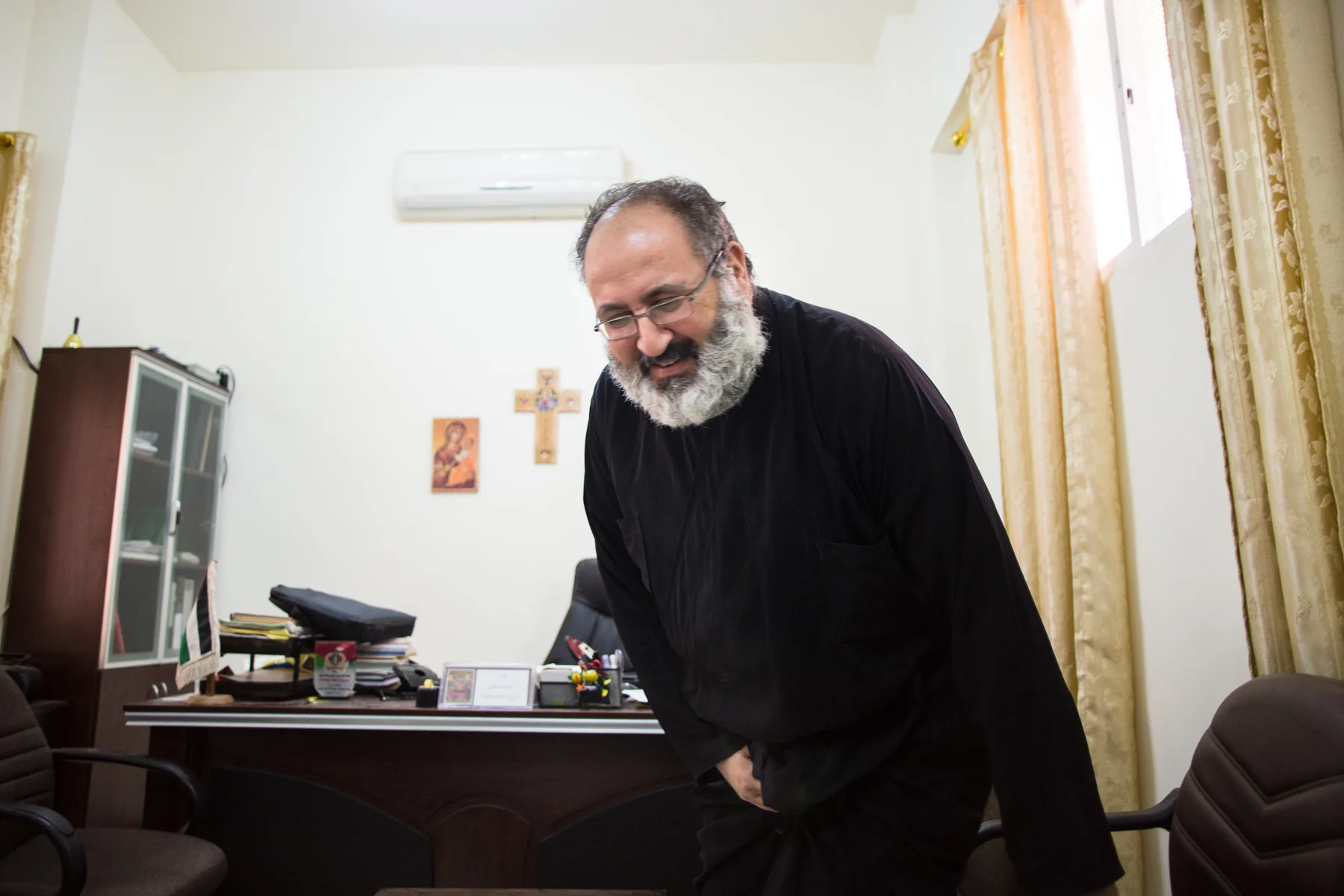 Father Dimitrius Samawi, the priest of the Orthodox Church in Mafraq, Jordan, sits in his office on Nov. 4, 2016. Father Dimitrius described it as his Christian duty to be a force for good in the Syrian refugee community, especially to help the children, no matter what religious background they come from.