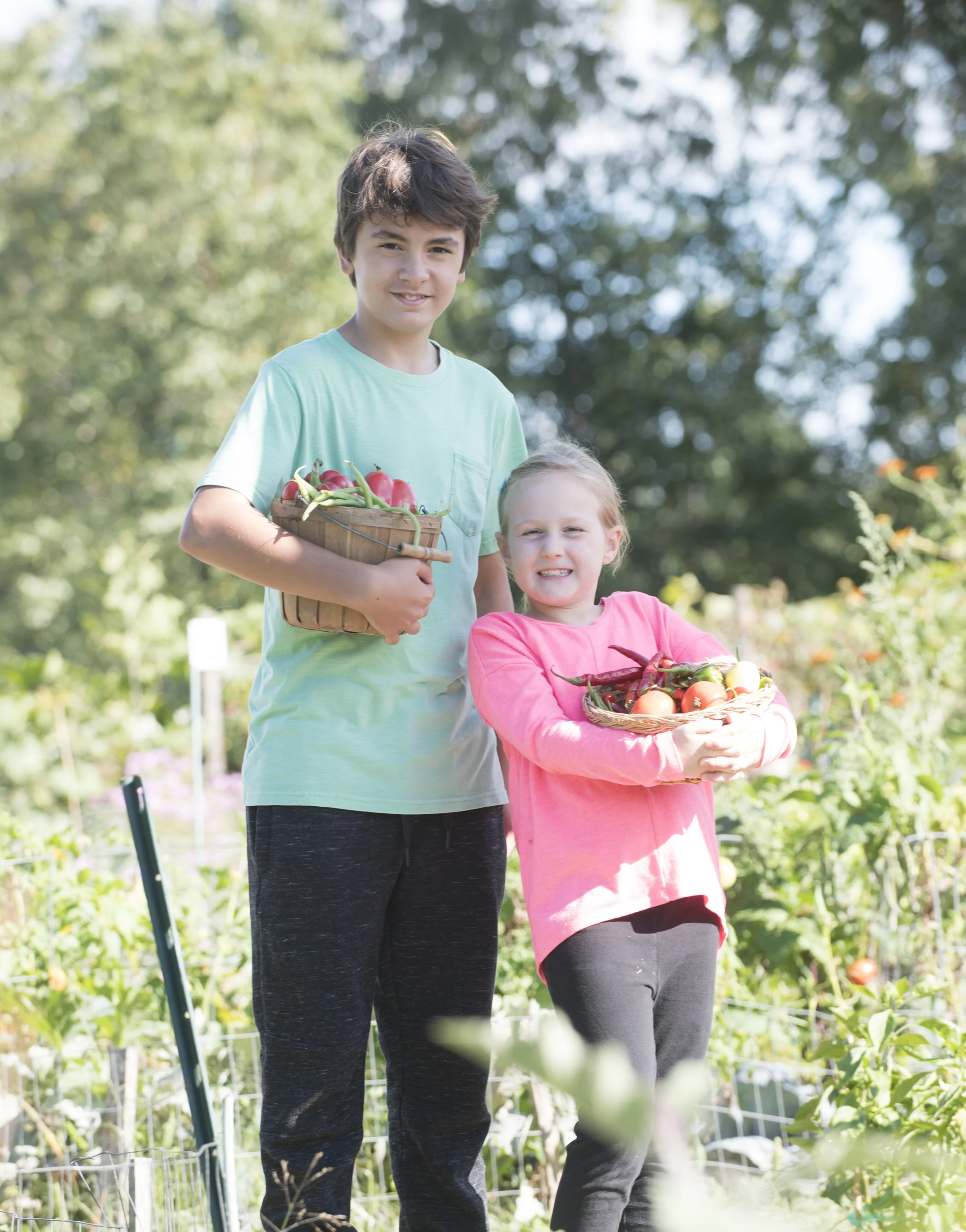 Girl and boy in garden with vegetable baskets.jpg