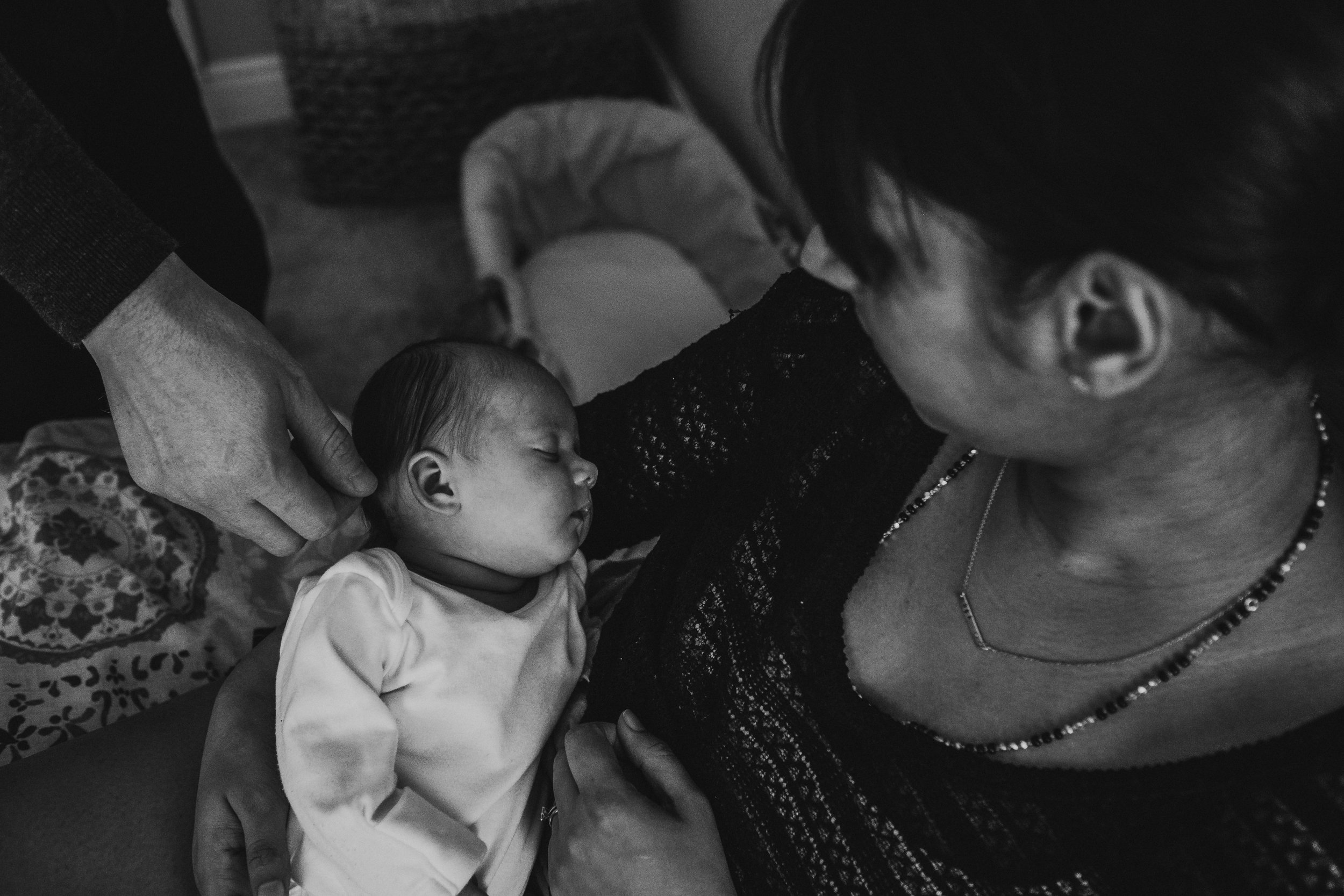 Documentary newborn photography session captures mother and father admiring their baby at their home in Chesterfield, Derbyshire.