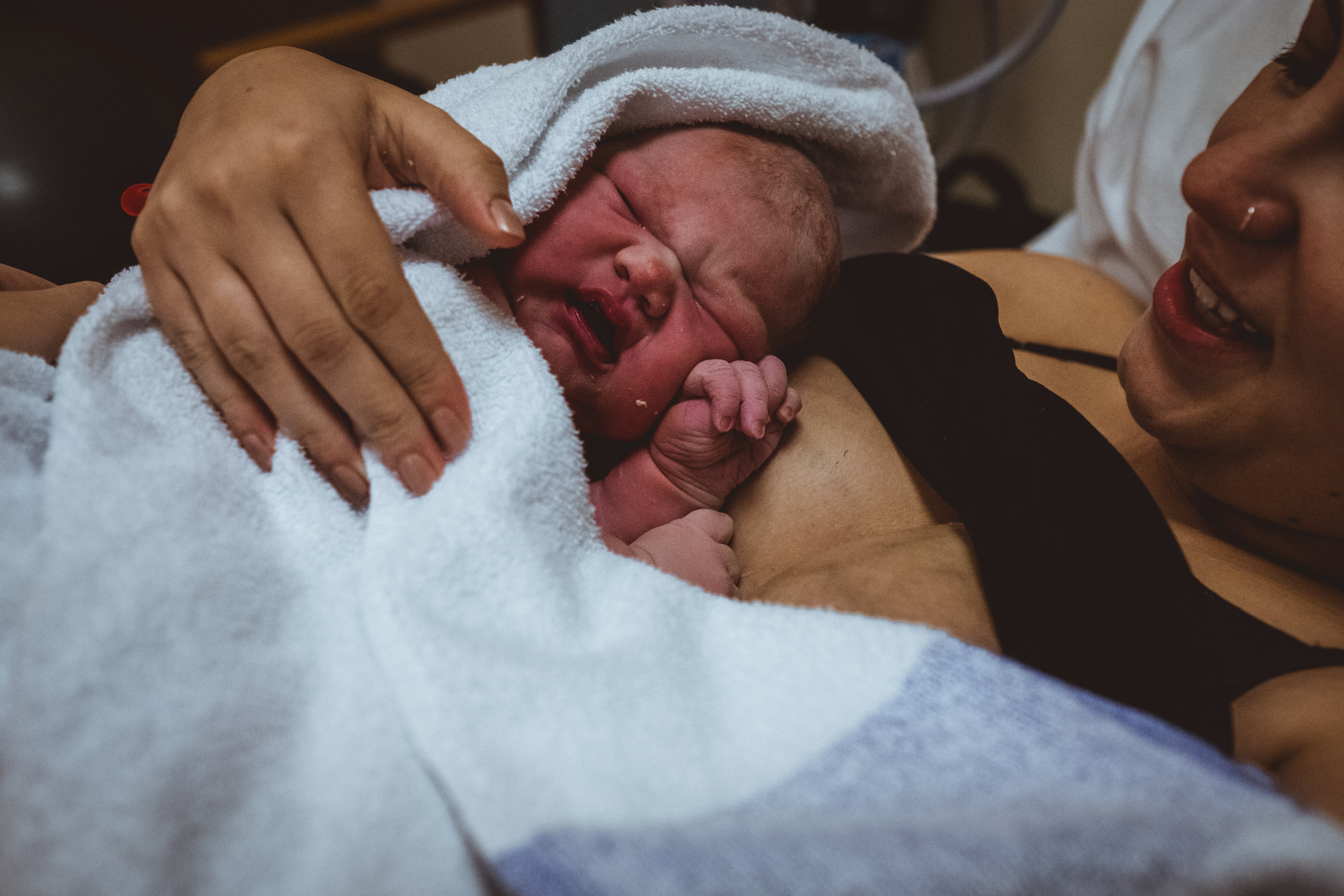 Birth Photographer, Sarah Marsden captures minutes old new born after her birth in Mansfield, Nottinghamshire.