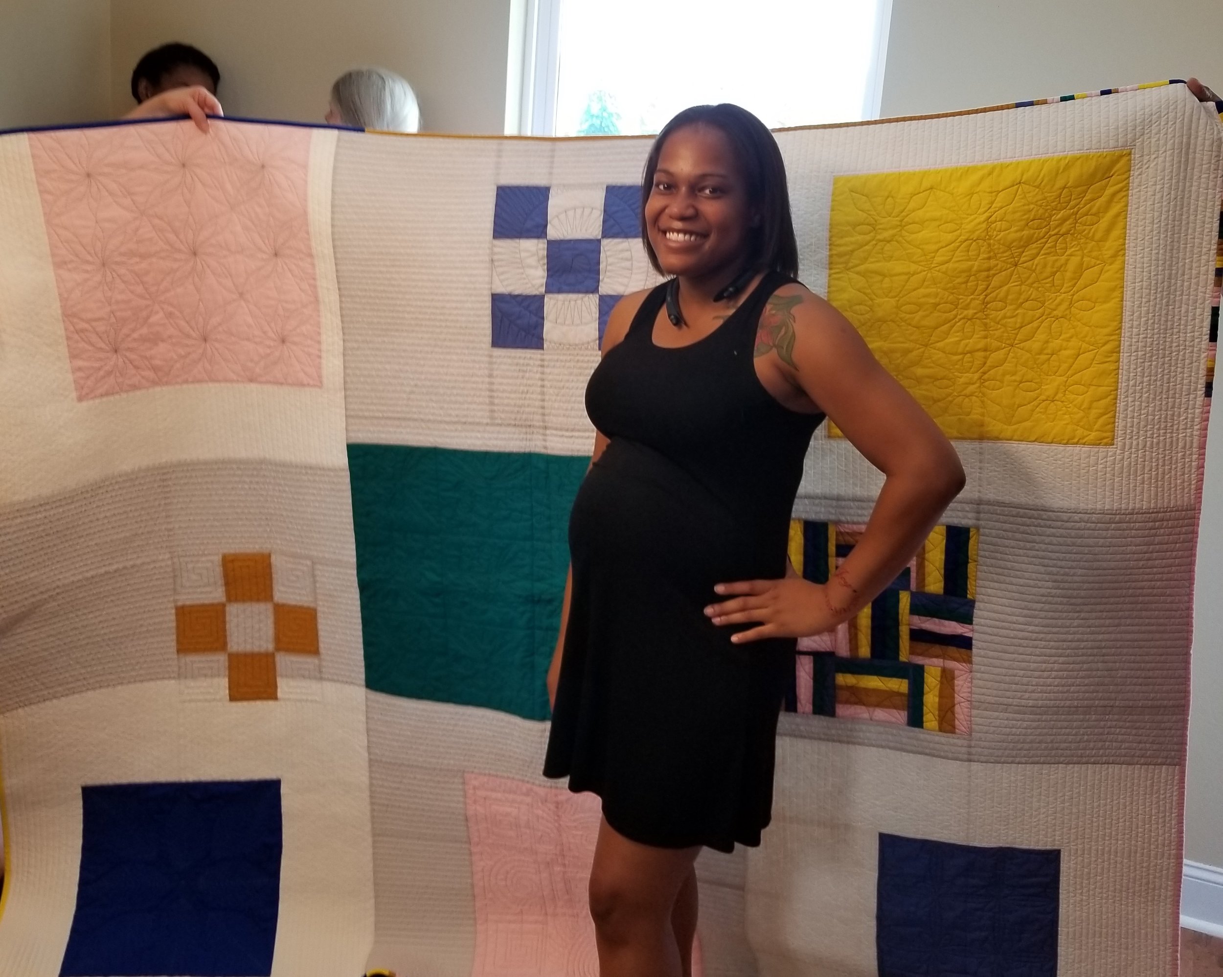 Homeowner Taneshia Hammonds poses with her quilt