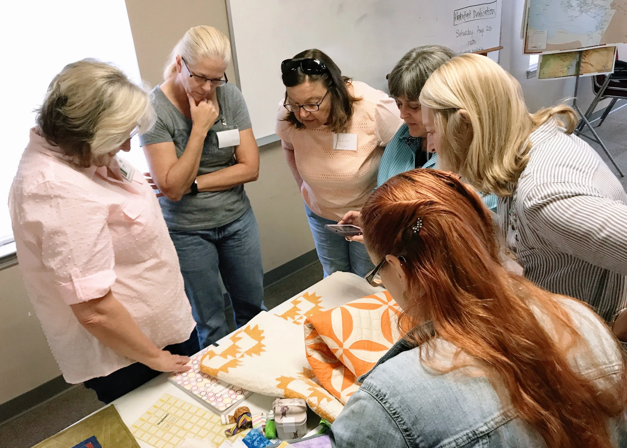 Karen (left) shows examples of various quilt binding and finishing techniques