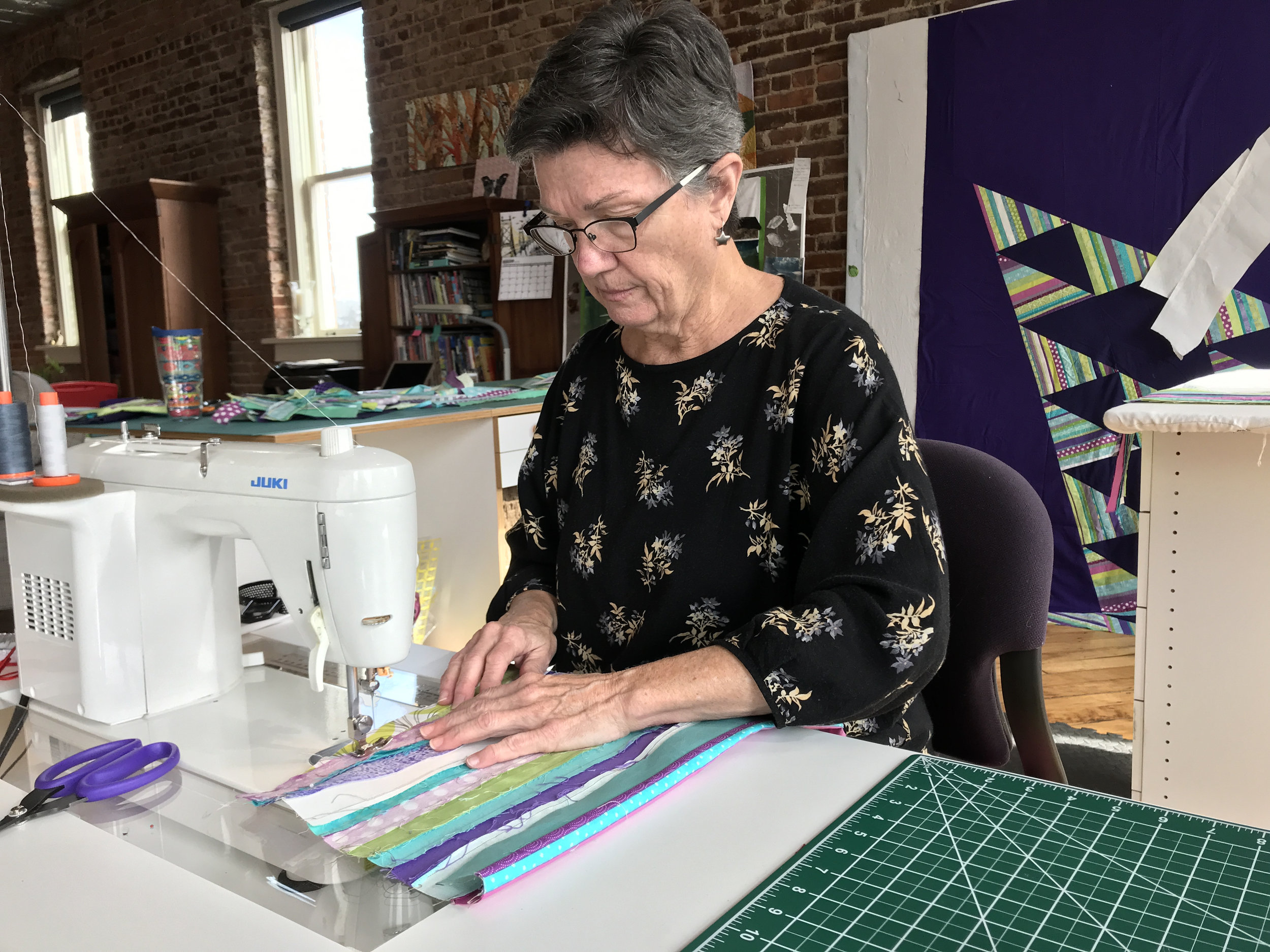 Mary sews strips to create the handle.