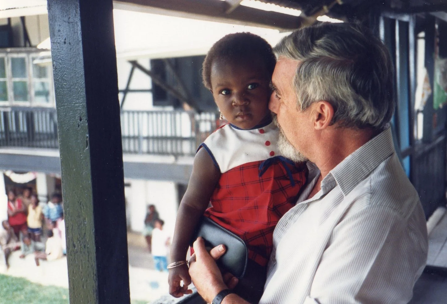 Guy Bekaert, French missionary based in Yaounde, with a child at Sakbayeme orphanage