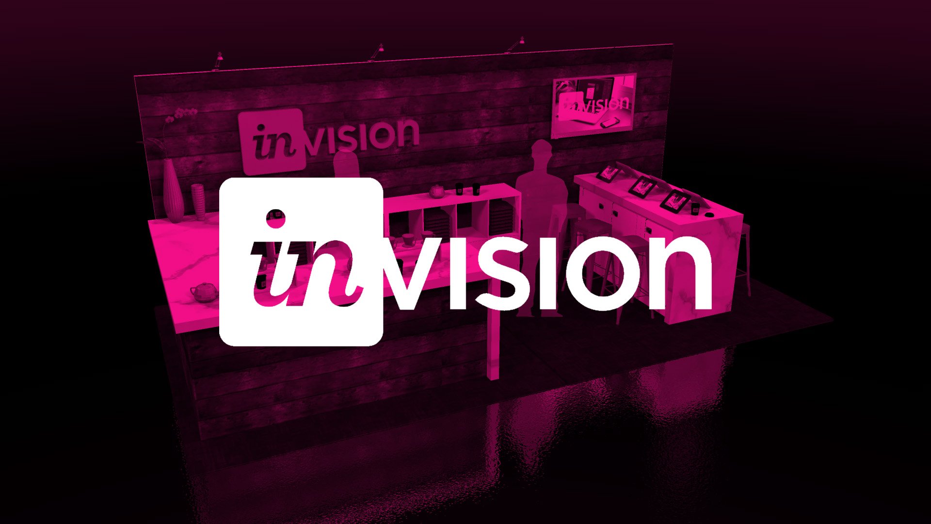 A trade show booth featuring a wooden graphic background, display screens, and seating, illuminated with lighting with a pink translucent title block overlay with the word "INVISION" in large white letters.