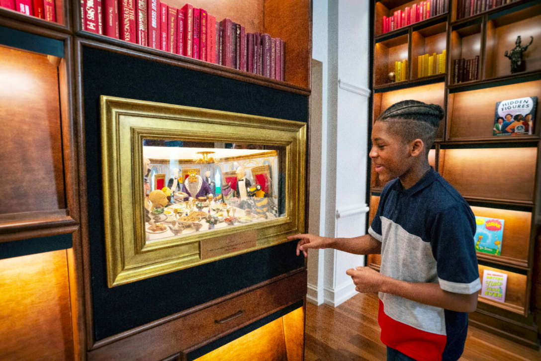 A visitor looking at the diorama of a scene from The Phantom Tollbooth