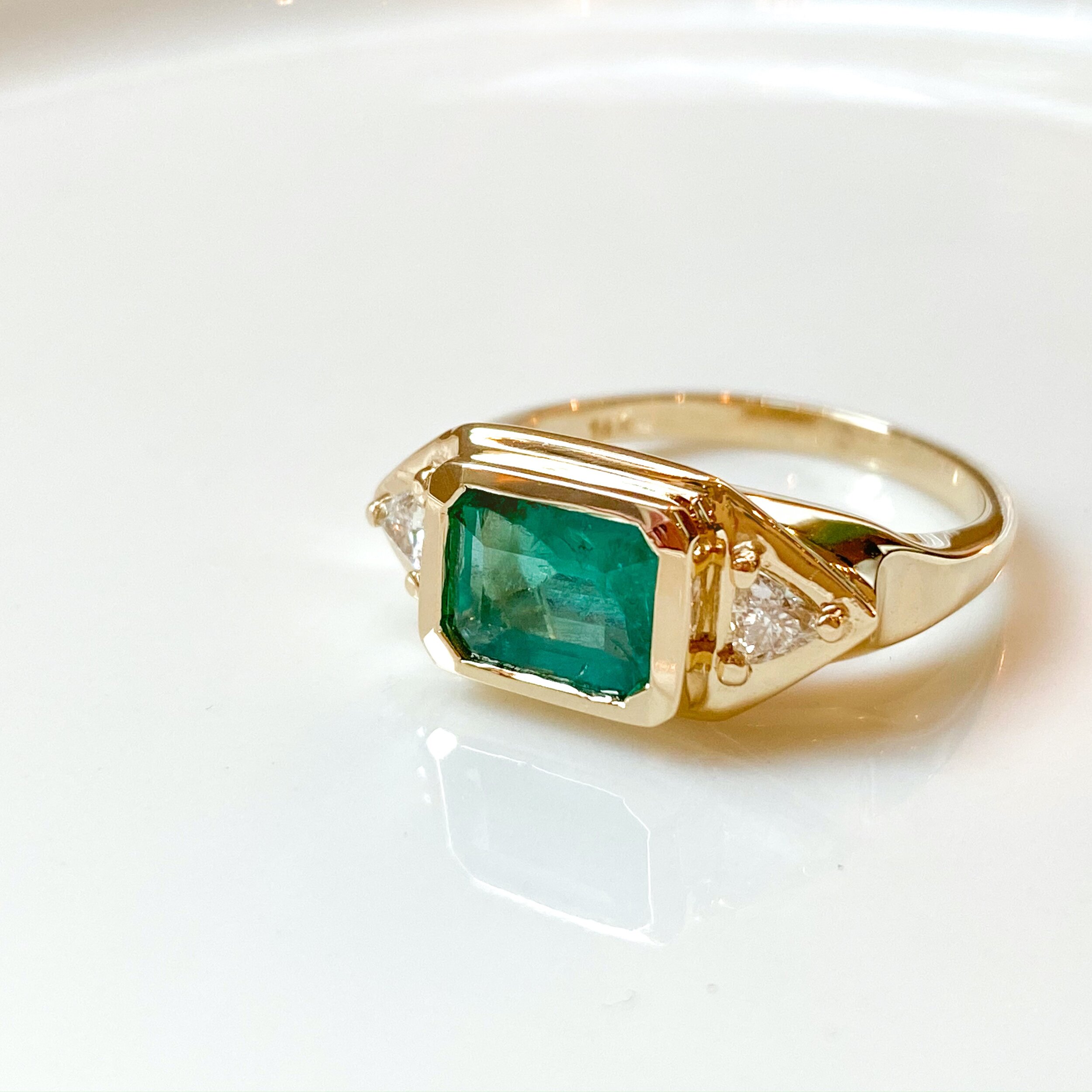 14k yellow gold ring with emerald and trillion side diamonds