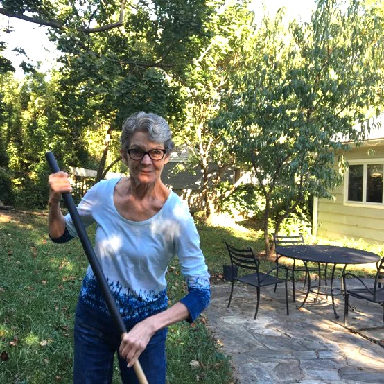 Kate rakes leaves in the yard of the home she has lived in for more than three decades.