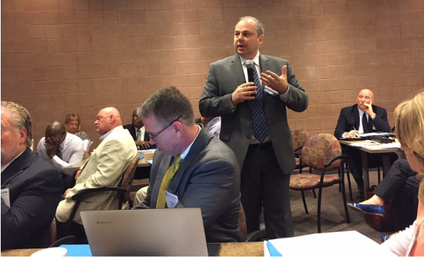 John Ladd, Administrator, Office of Apprenticeship, U.S. Department of Labor (standing) gives information on the economic benefits of the Registered Apprenticeship Program.