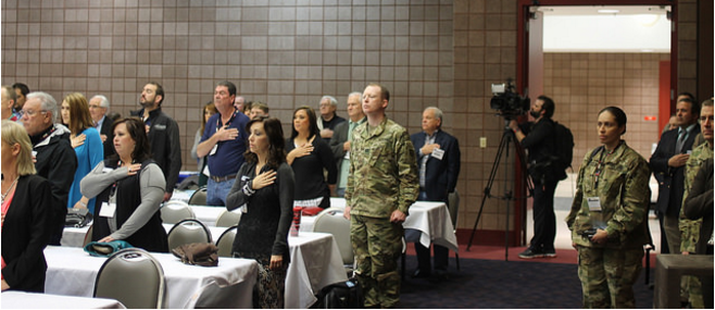 Employers and Active-Duty Service Members Stand for the National Anthem during ESGR signing ceremony sung by Ms. Janine Stange.