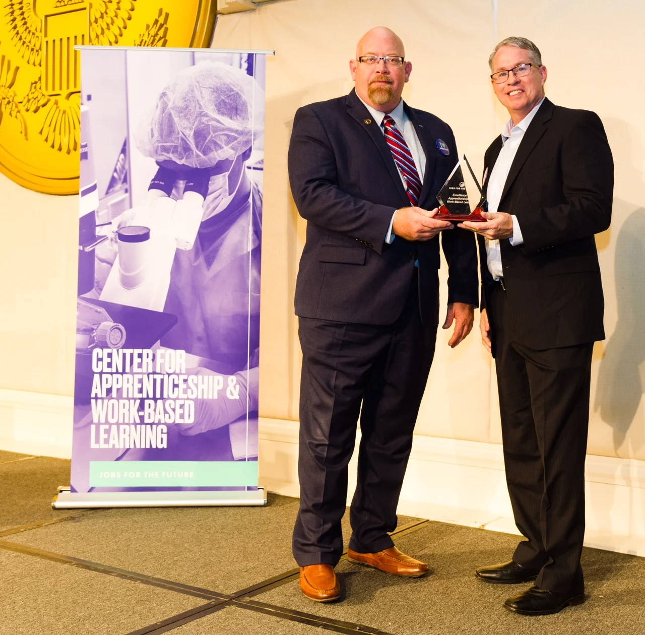 Dave Harrison, FASTPORT Executive Director of Apprenticeship (left) and Brad Bentley, FASTPORT President (right) displays award for Serving Veterans with Apprenticeship & Work-Based Learning at JFF Event