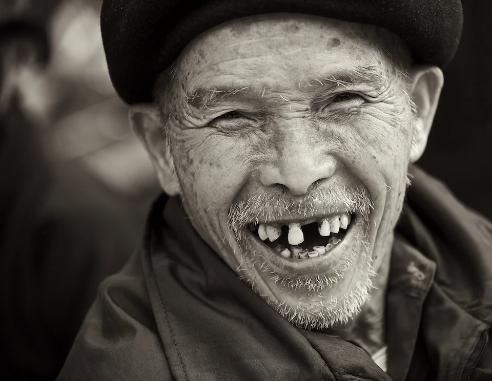 A happy man in the Dong Van market in Vietnam. Image by New Orleans based travel photographer, Marc Pagani