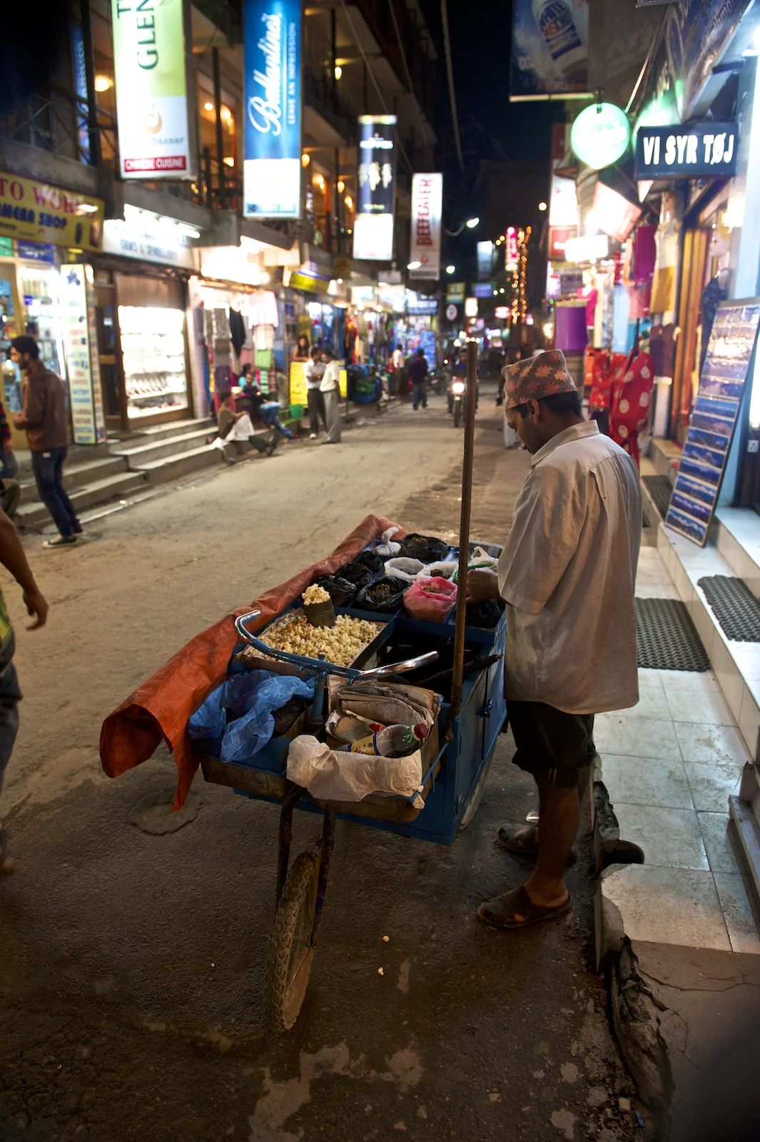 A mand sells food in the tourist area of Kathmandu, Nepal, Thamel. Image by New Orleans based travel photographer, Marc Pagani - marcpagani.com