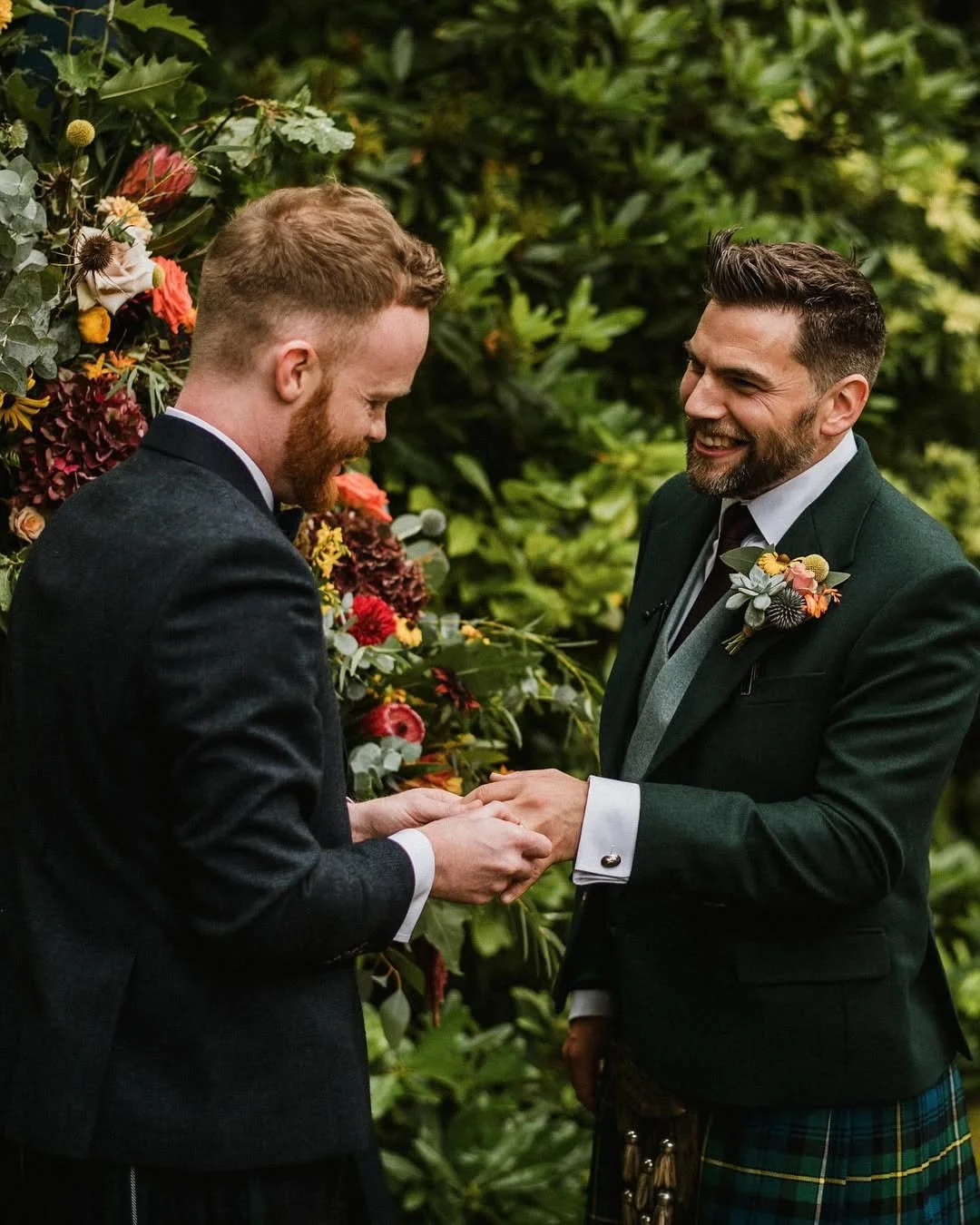 male couple putting on their alison macleod bespoke wedding rings in scotland