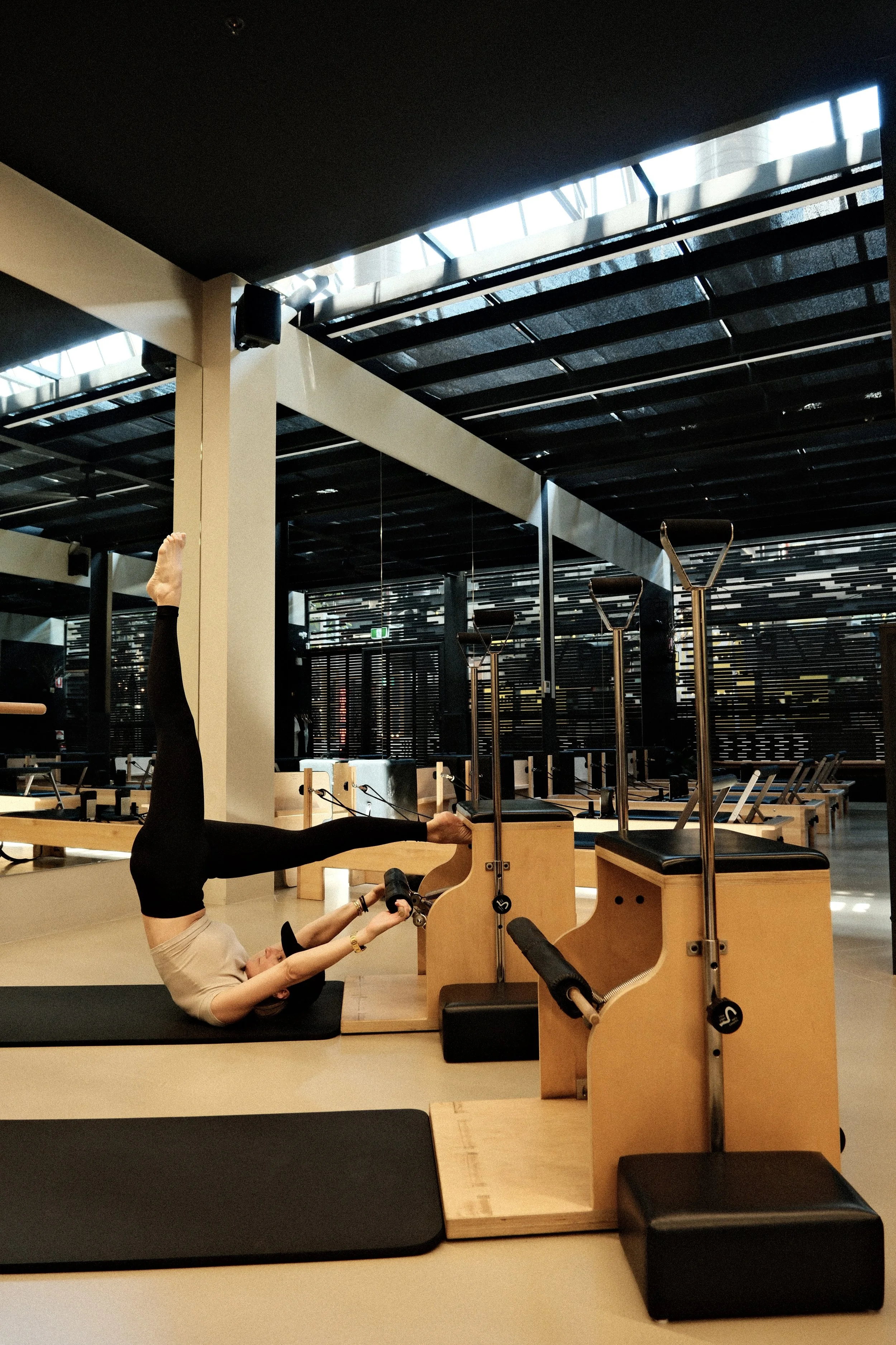 Woman doing equipment pilates on a reformer machine at Athletica Pilates, Forest Lodge Sydney