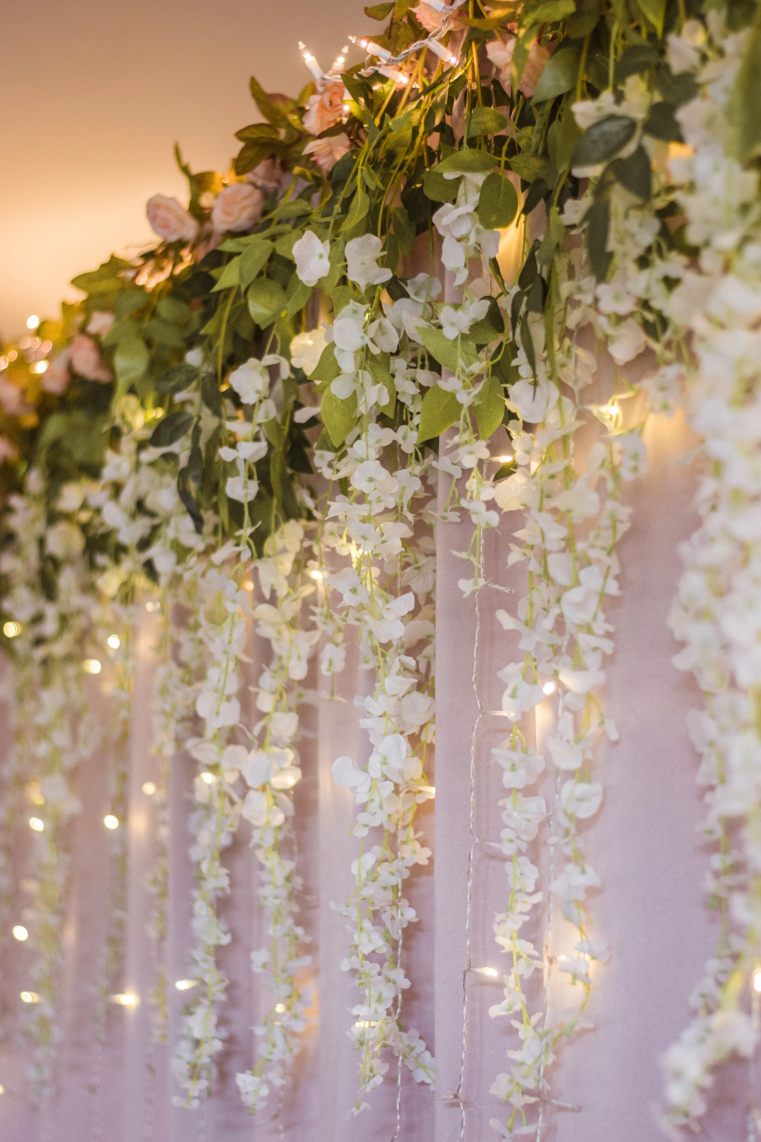 A close-up of the backdrop we created. All of the elements (flowers, curtains, lights) were purchased on Amazon prime separately and assembled by us.