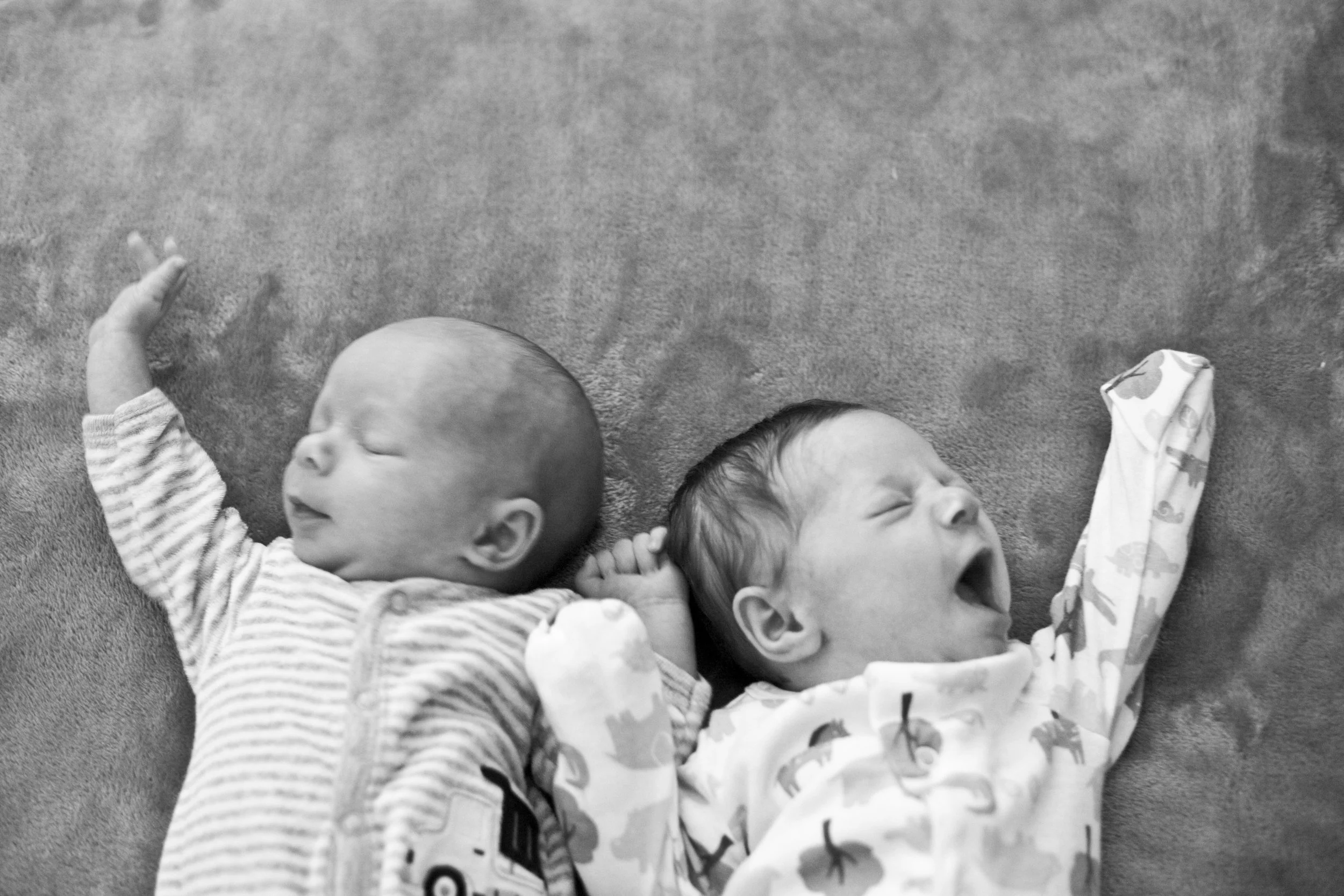 Newborn twin boy and girl stretching