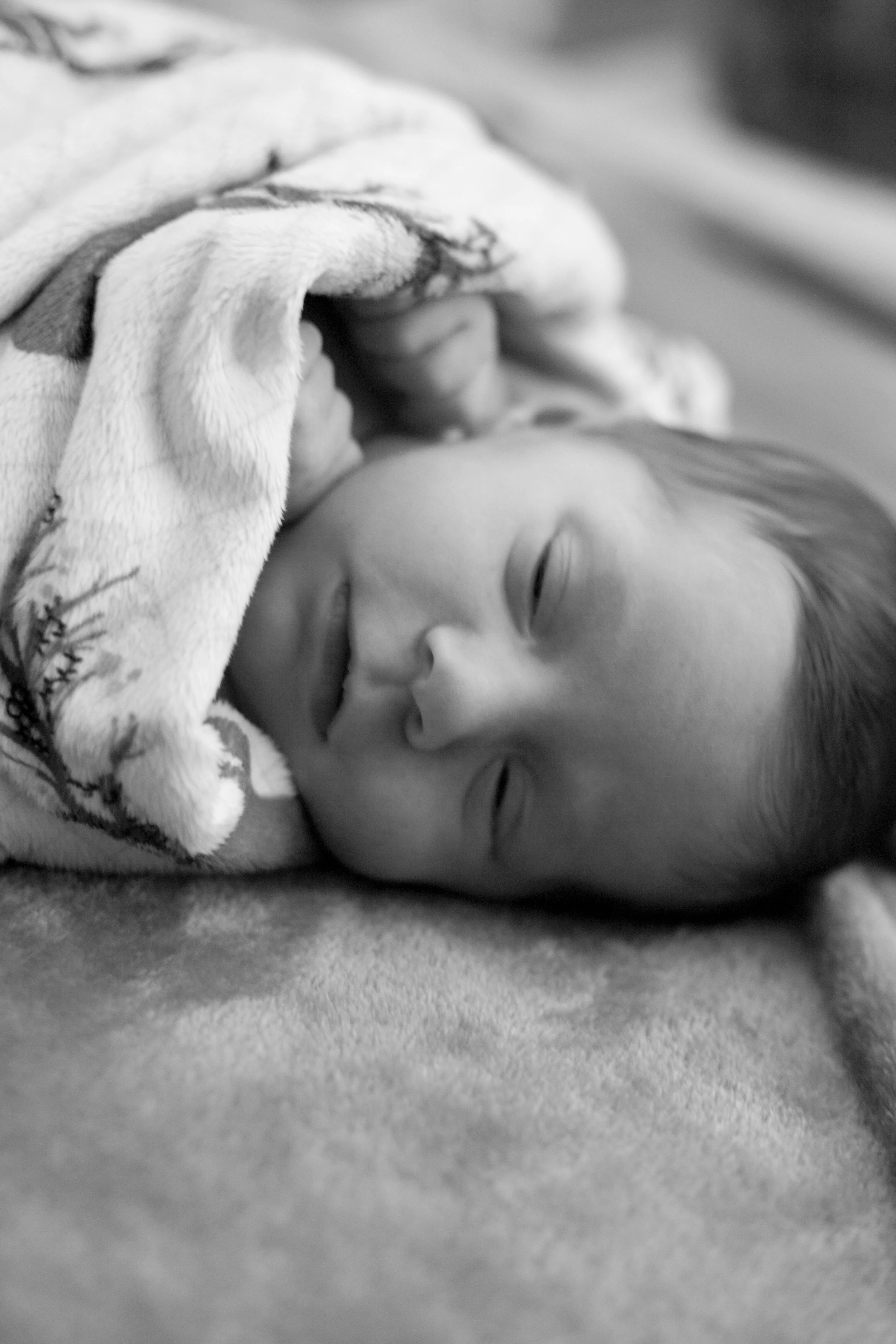 Newborn twin girl sleeping with blanket
