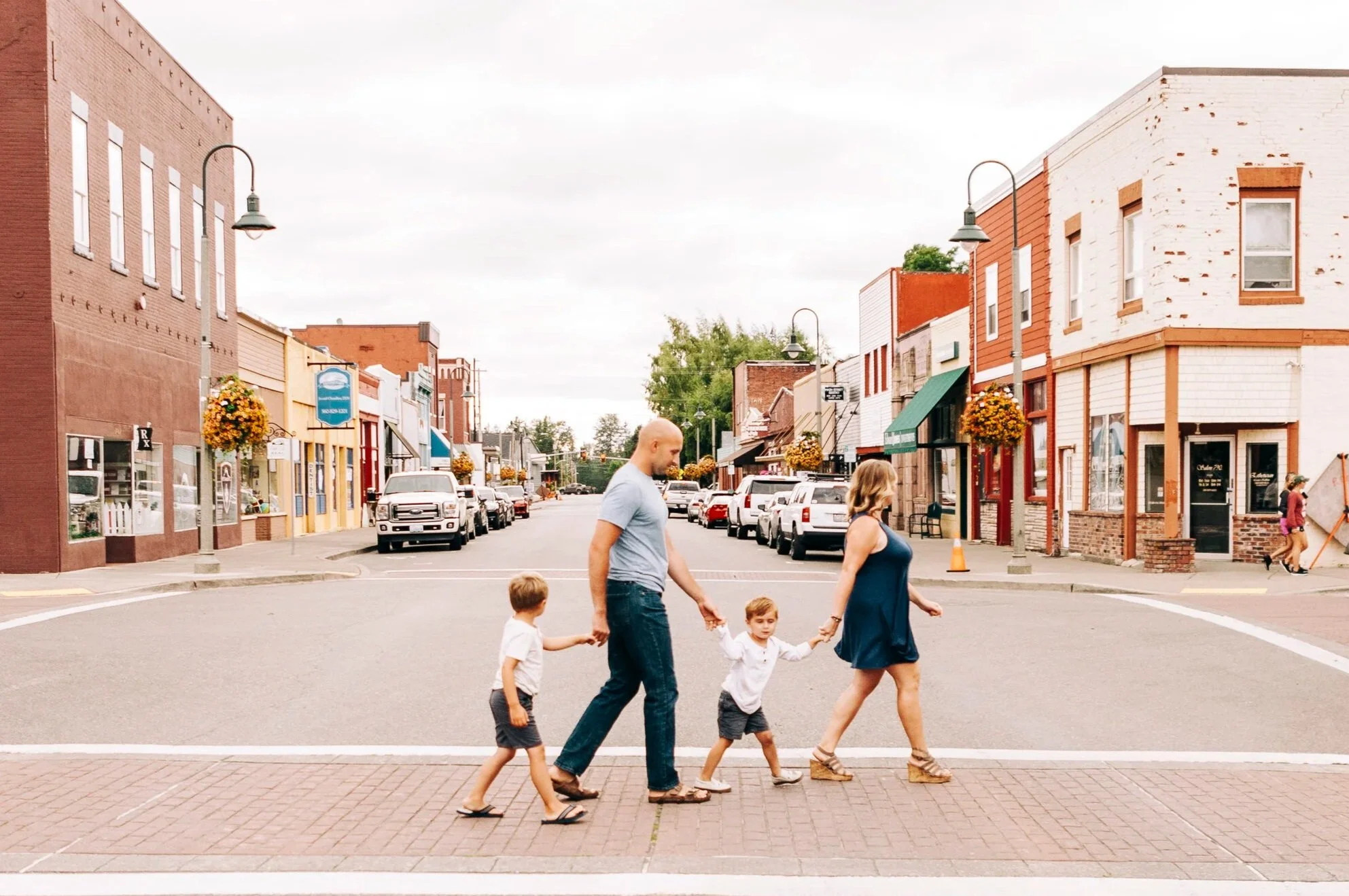 Family of four walk across a cross walk in down town Buckley, WA.