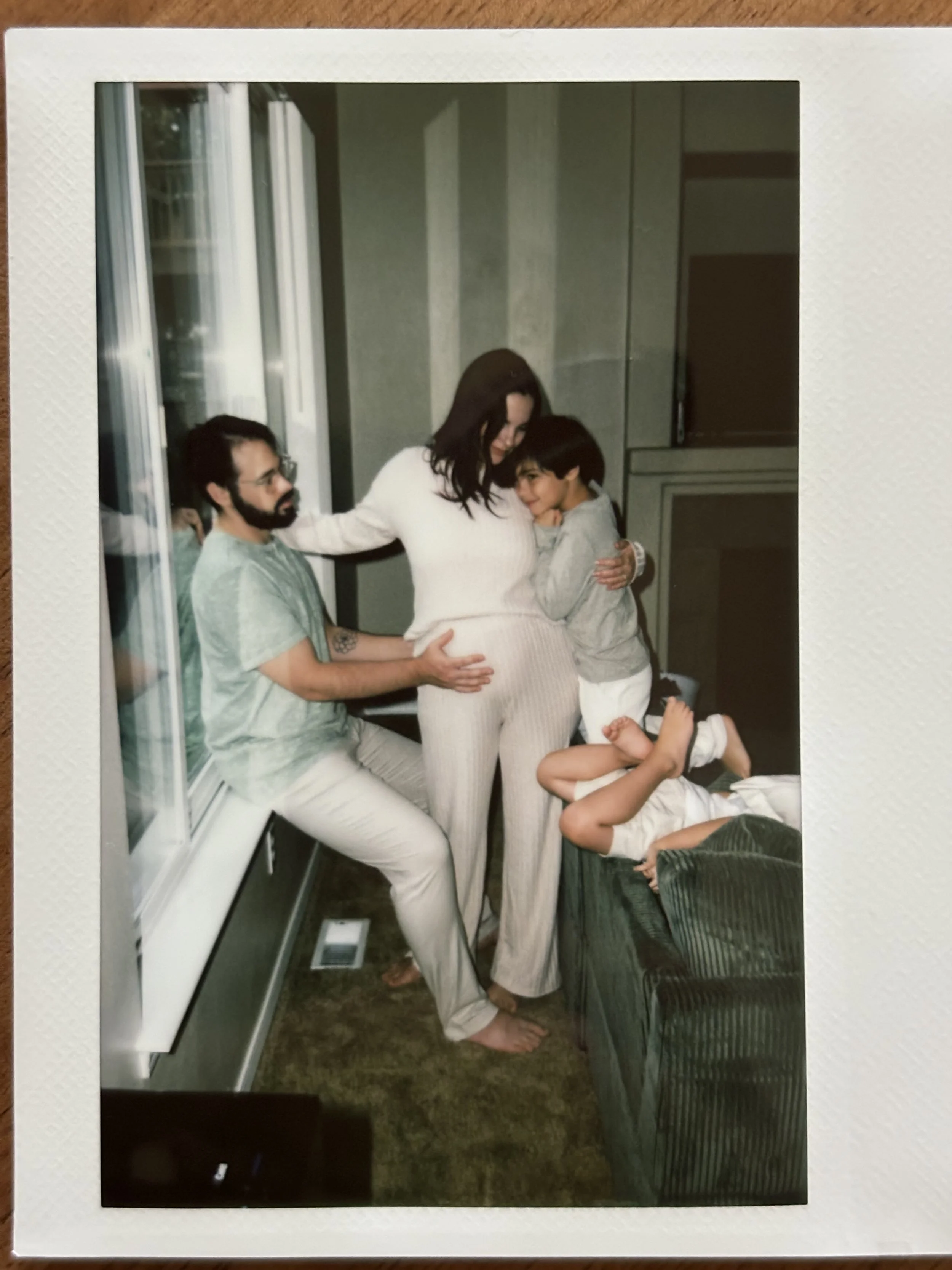 Polaroid photo of a seattle family during a maternity session in their home.