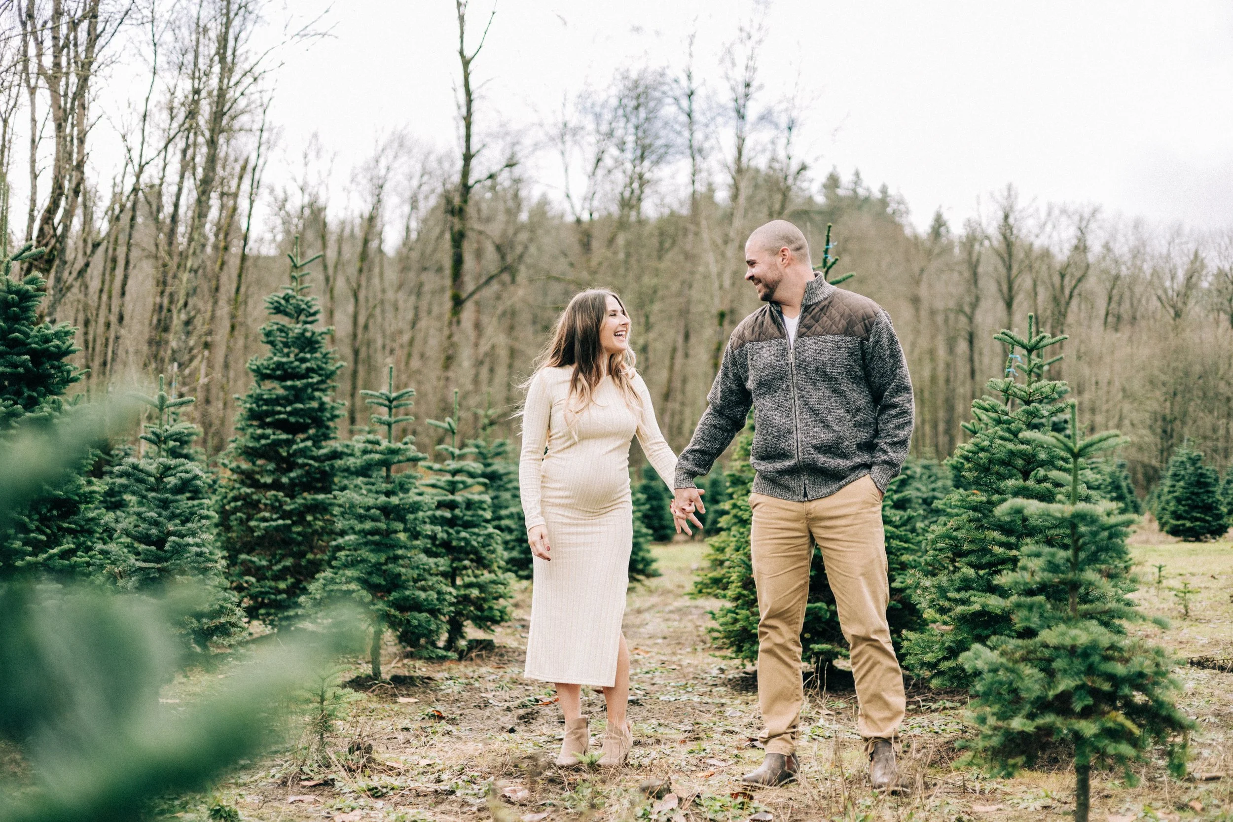 Pregnant couple take maternity photos at seattle area christmas tree farm.