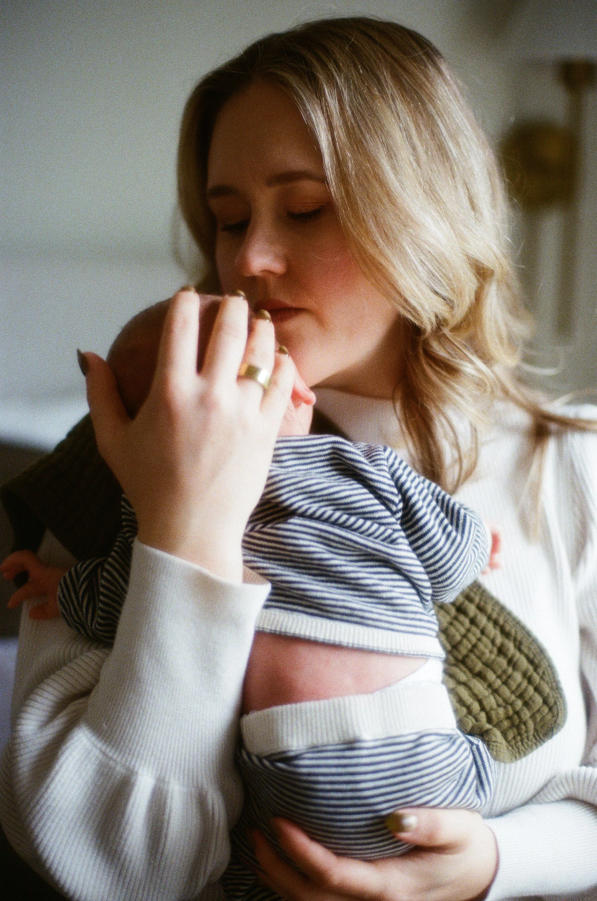 Mother holds her newborn baby boy close to her as she takes in the magic of motherhood in Seattle.