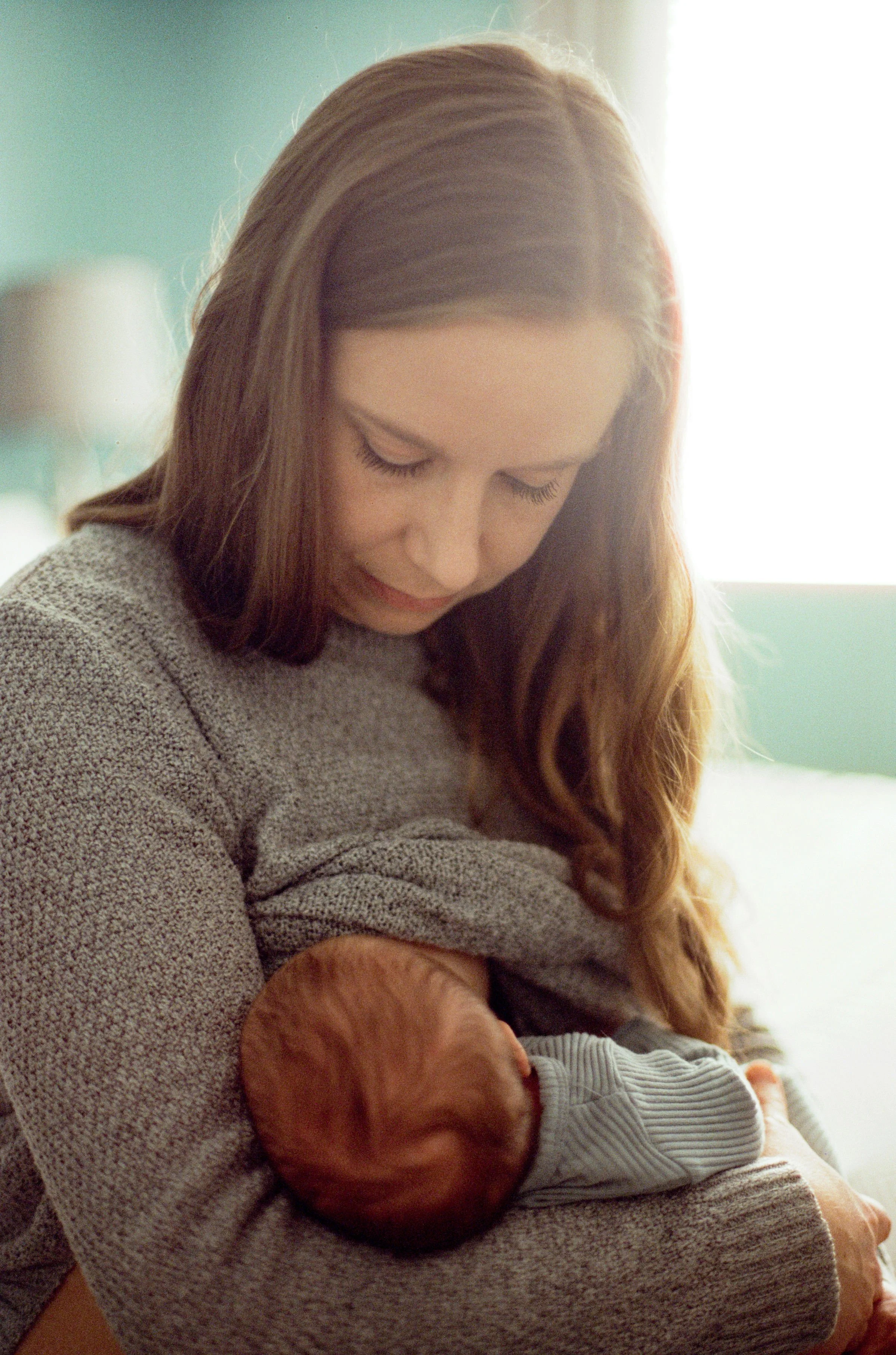 Lifestyle newborn photographer capturing breastfeeding moment between mother and baby in Tacoma home