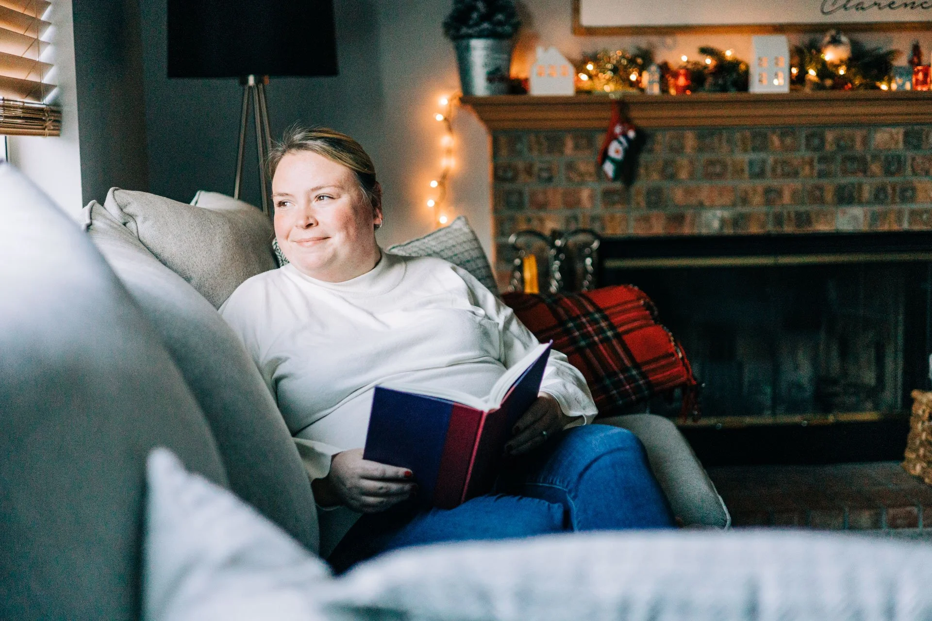 Sam Dorn from Learning to Bloom poses with good book on her couch.