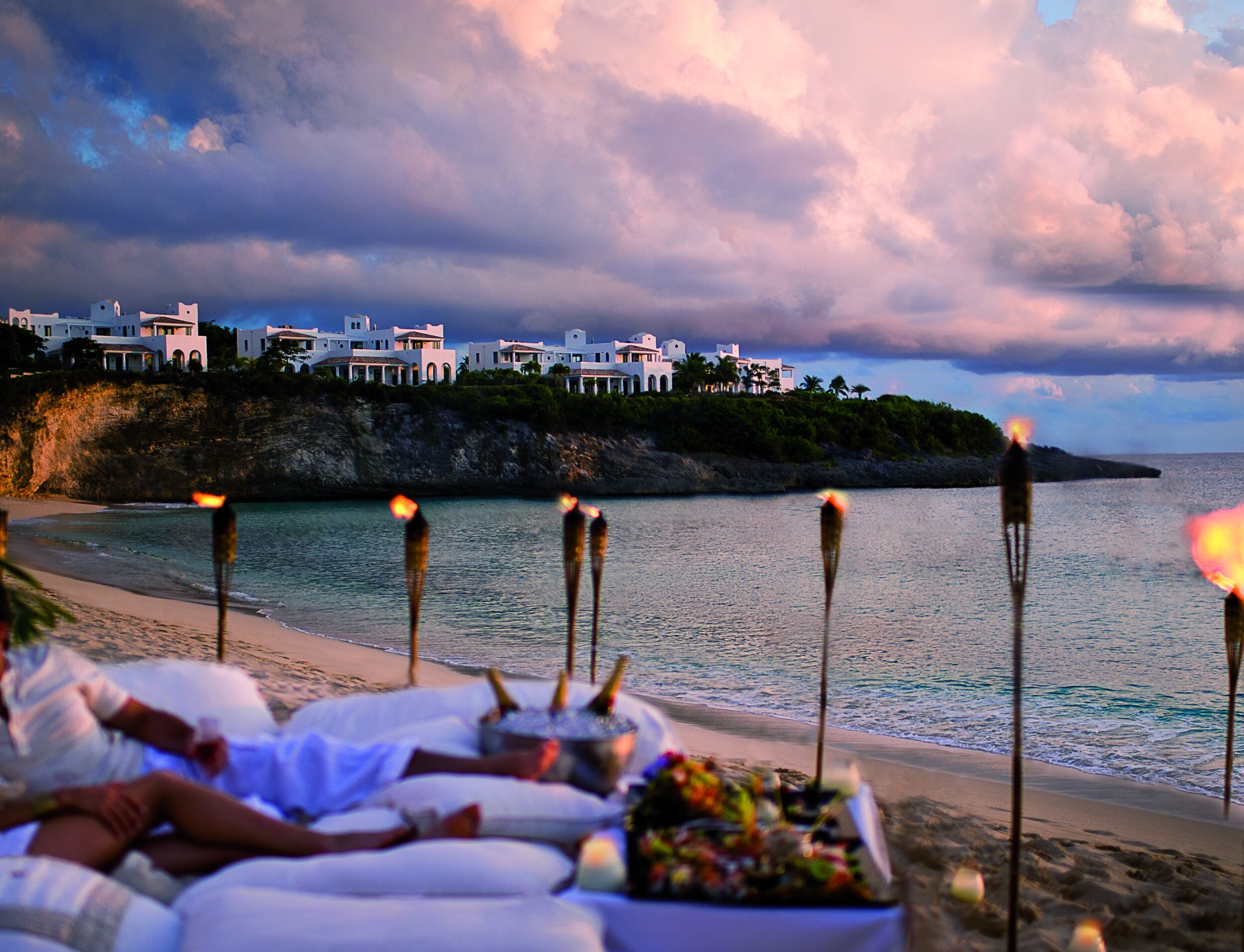   Private dining on the beach, with the villas in the background (photo credit: Belmond)  