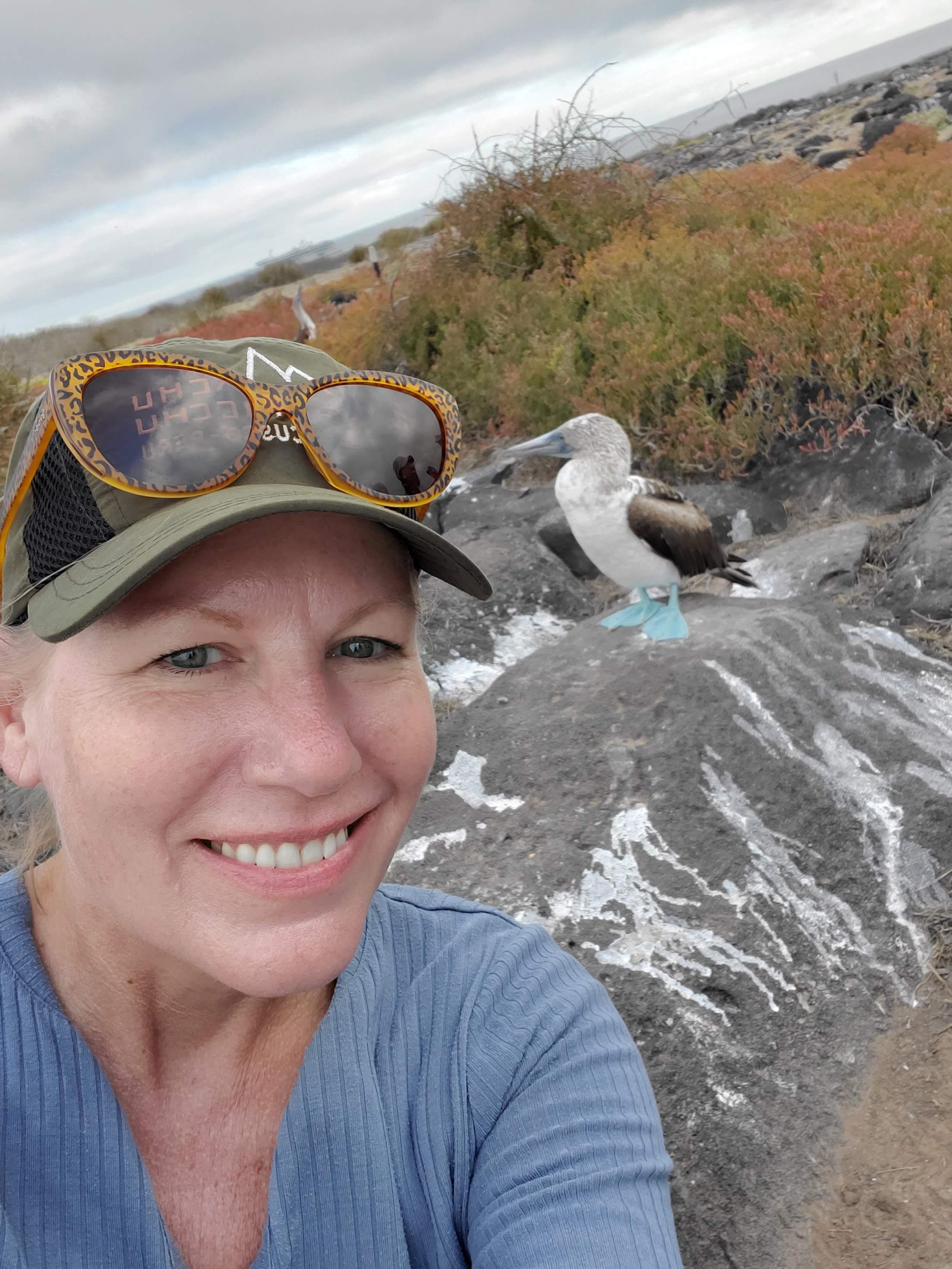 Poe Travel client with a blue-footed booby in the Galapagos Islands