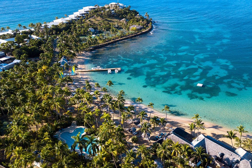 Aerial shot of the private beach at Curtain Bluff all-inclusive resort in Antigua looking out at the Caribbean Sea