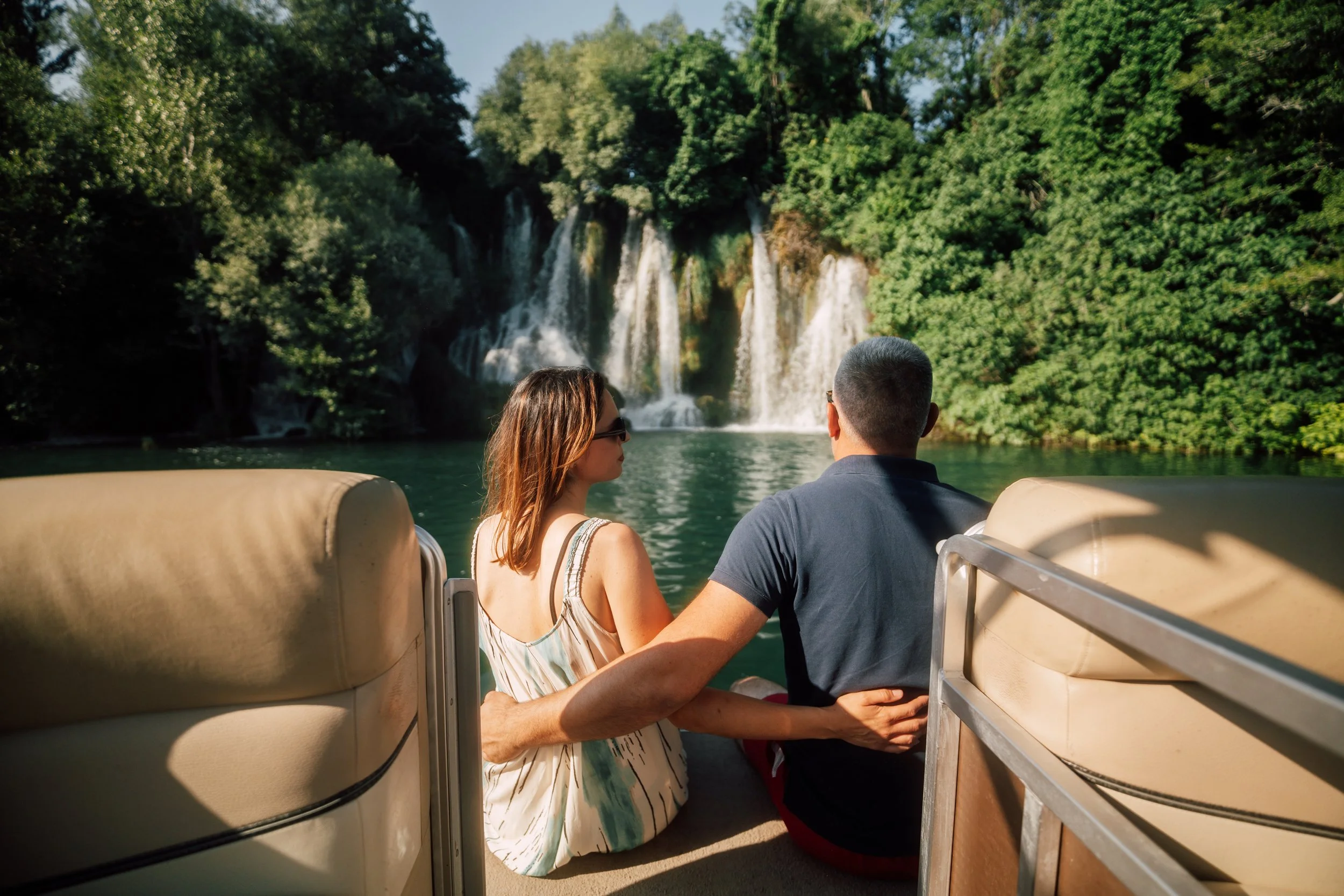 A couple looking at the waterfalls in Krka National Park in Croatia from a private boat