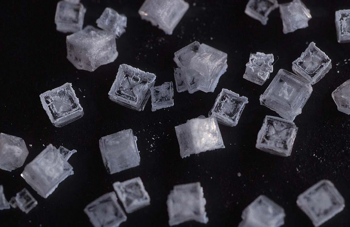 The regular shape of the salt crystals is caused by the arrangement of the atoms that make them up.
