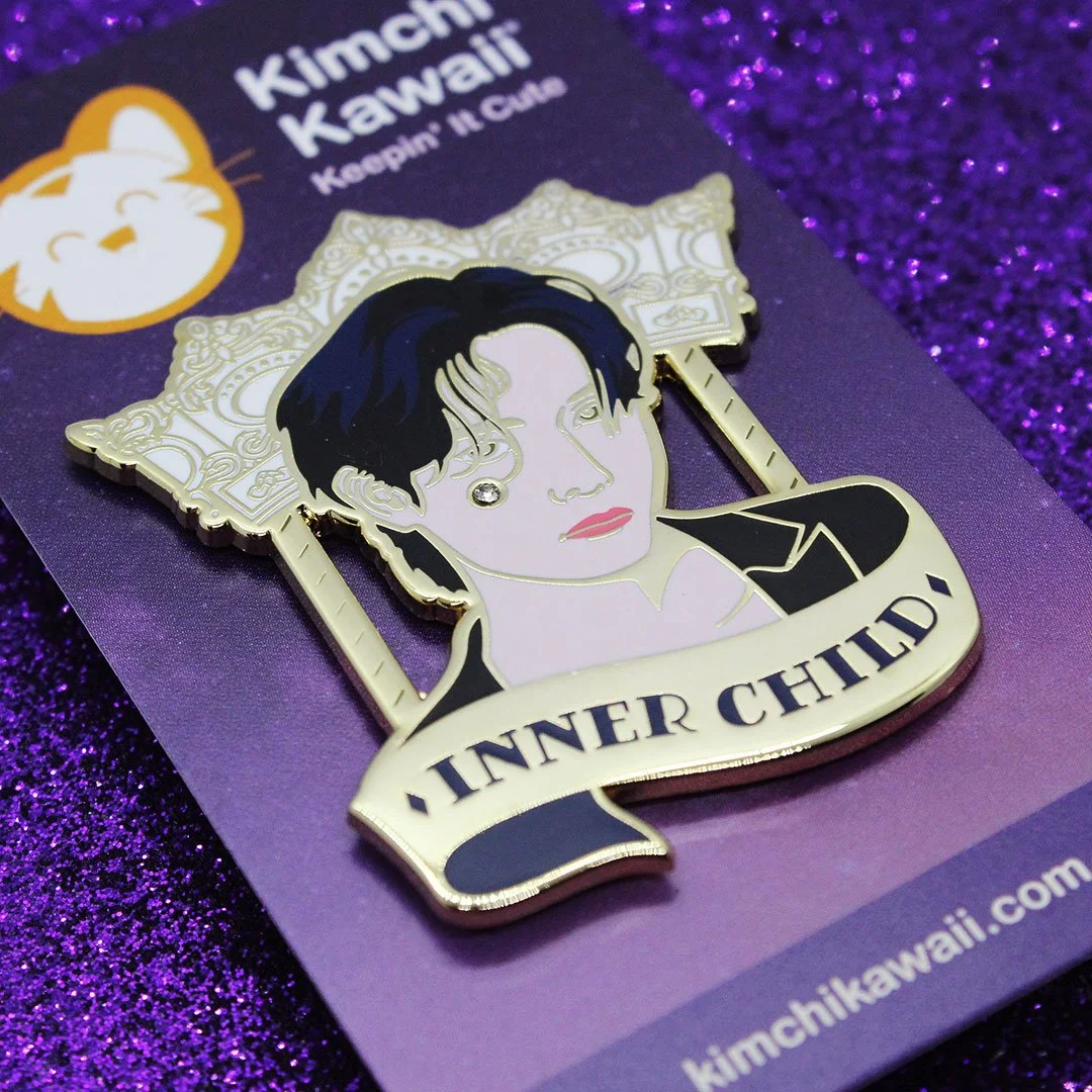 Detail of enamel pin of Taehyung showing the rhinestone on his cheek.