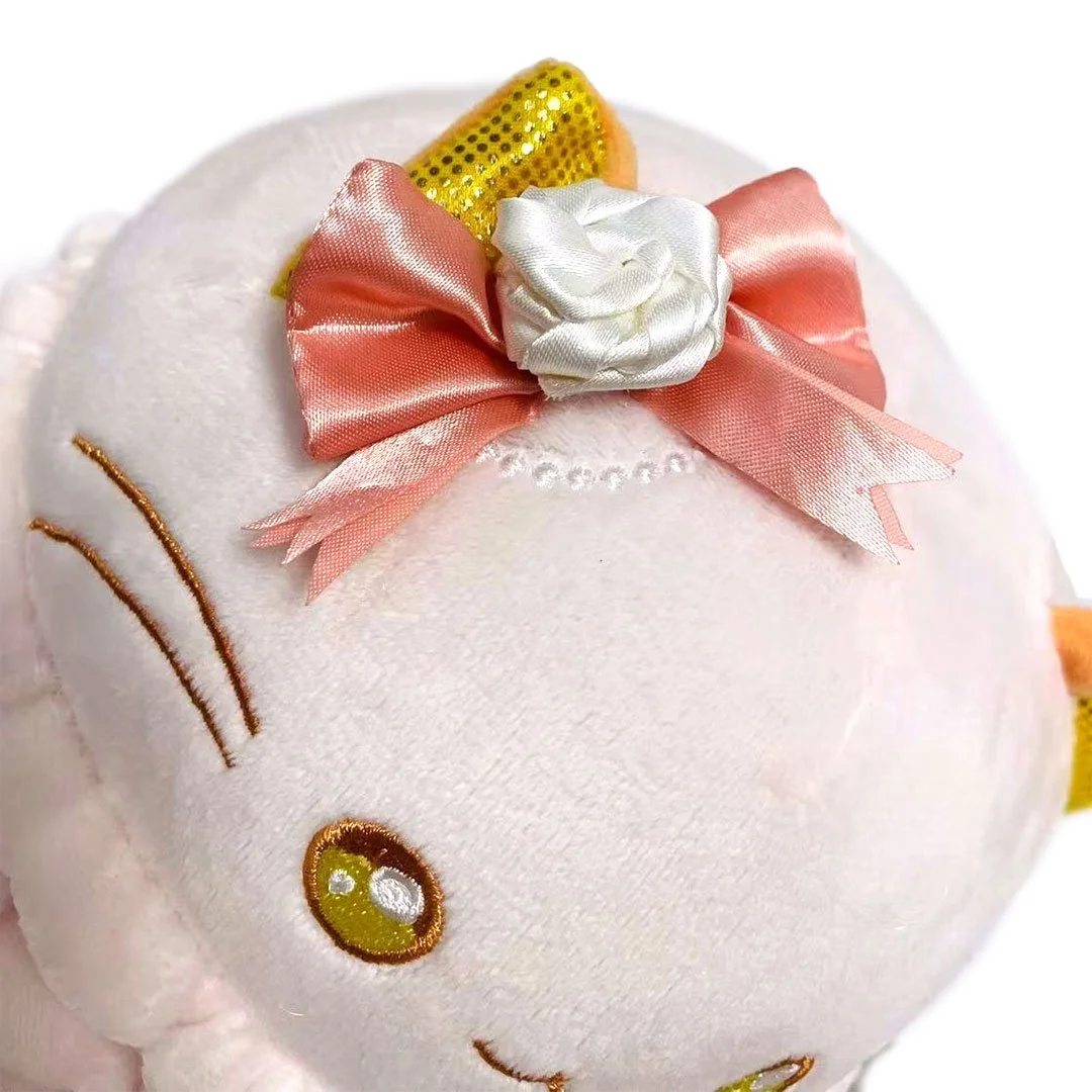 Champagne macaron kitty plush with a bow at her ear.