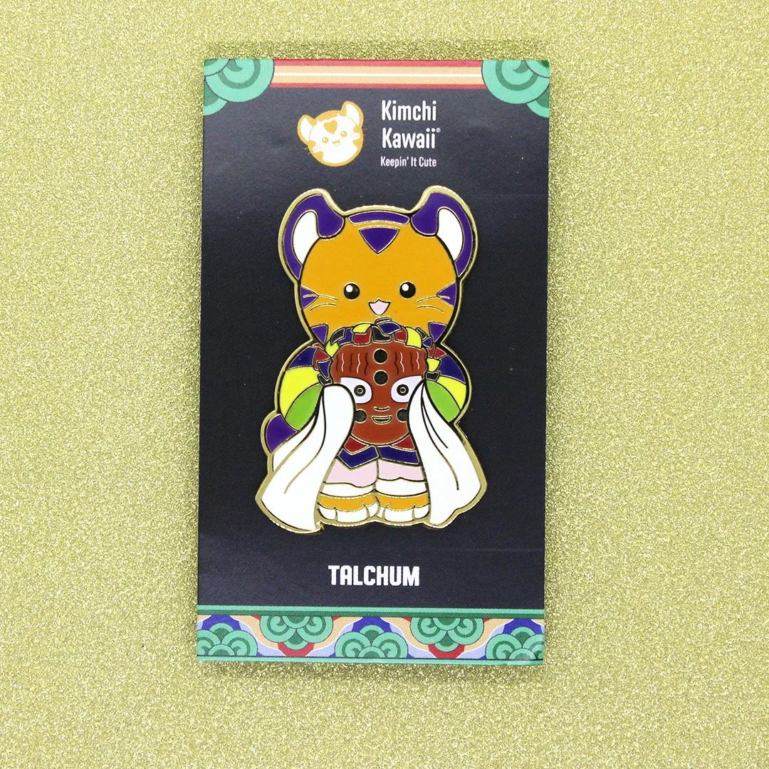 Enamel pin of Korean tiger in hanbok holding a talchum mask.