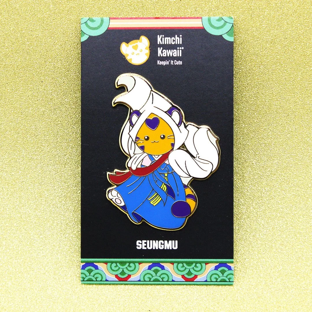 Enamel pin of a tiger in Korean hanbok doing a traditional dance with long flowing white sleeves.