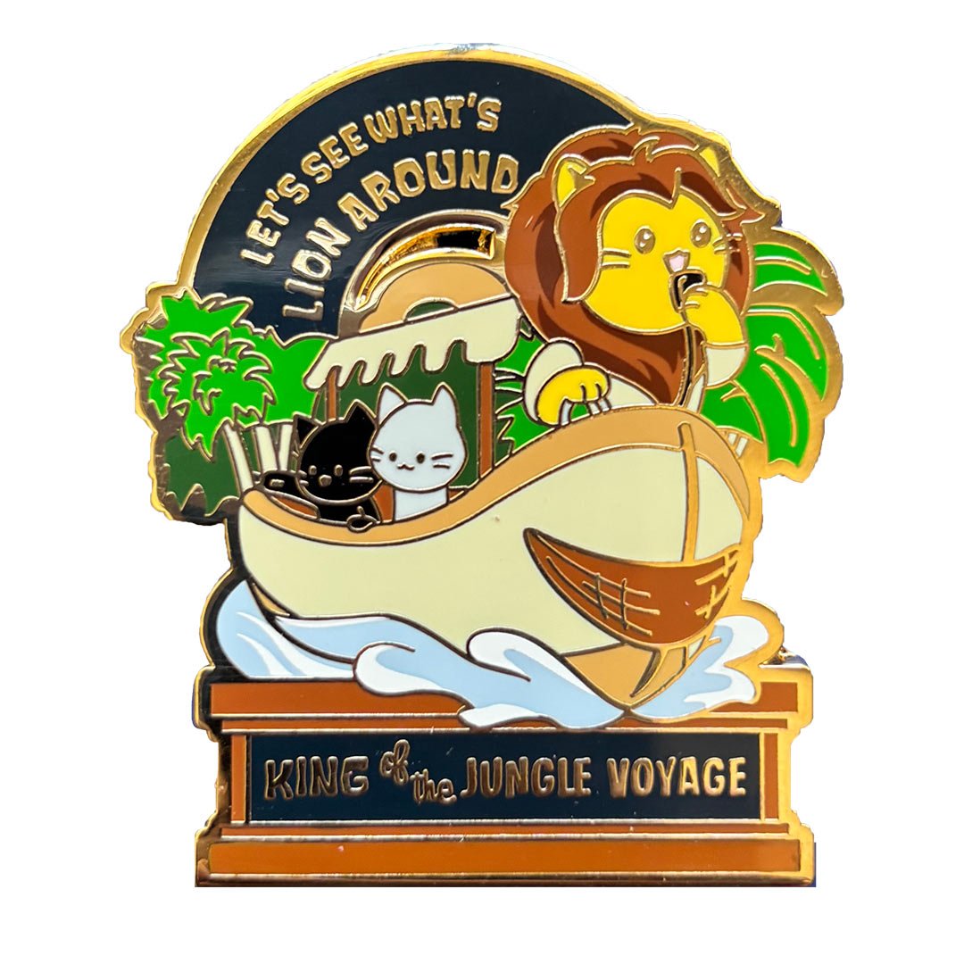 Enamel pin of two cats and a lion in a boat. Text says 'Let's see what's lion around' and 'King of the Jungle Voyage'.