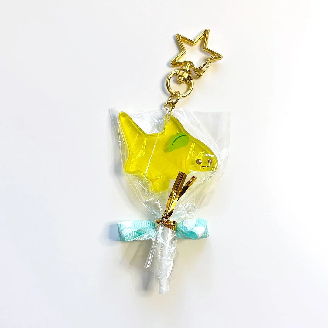 Yellow acrylic lemon shark lollipop charm with a gold clasp.
