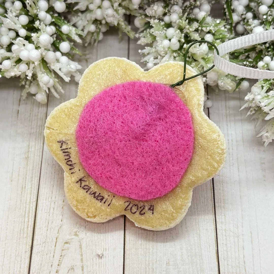 Back of a flower cookie ornament with felt and the words 'Kimchi Kawaii, 2024'.