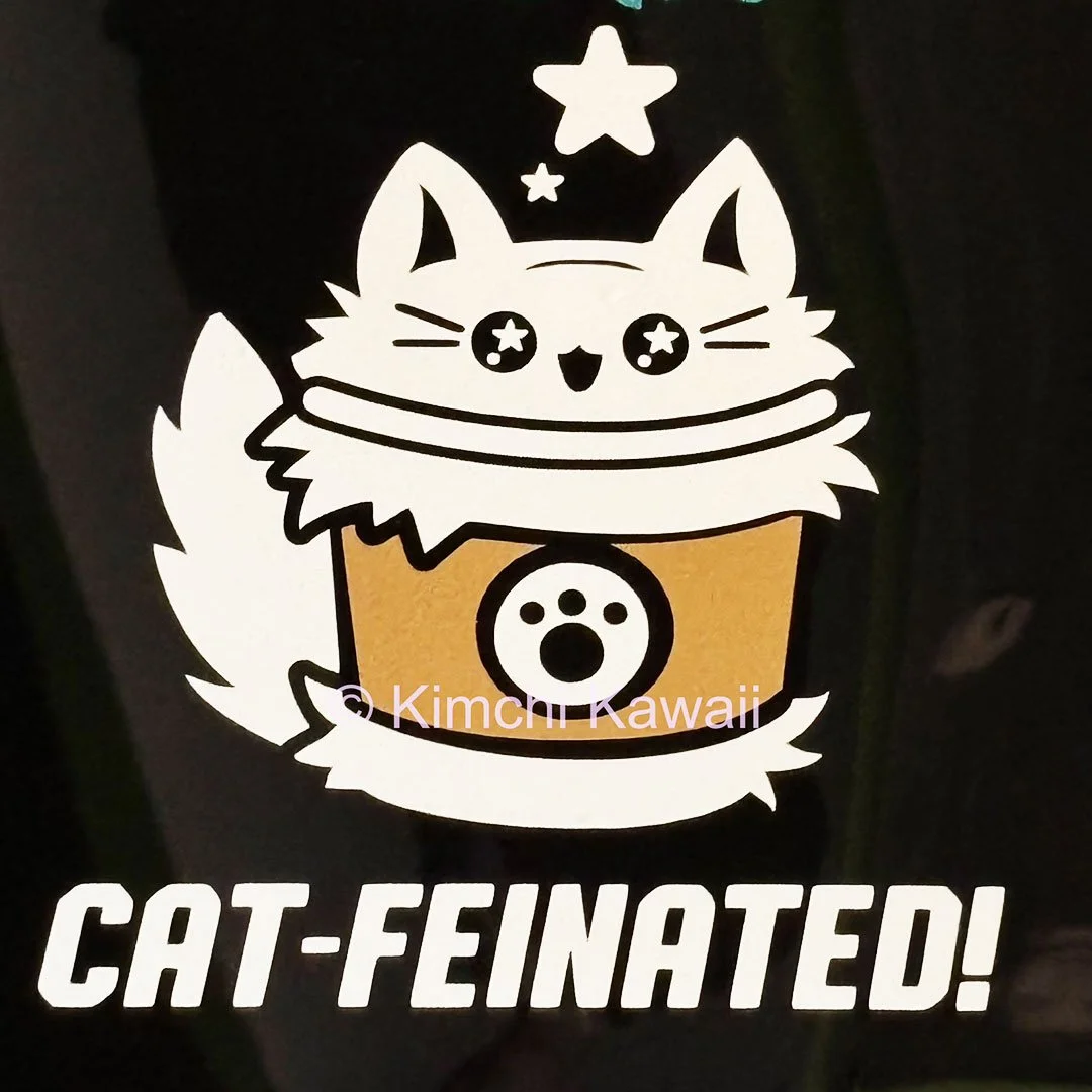 White and brown sticker of a fluffed up coffee cup kitty. Text says 'Cat-feinated'.