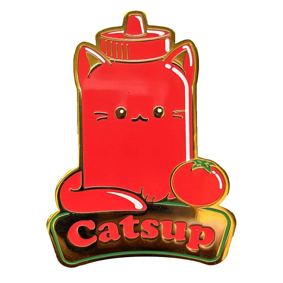 Pin of a cat shaped bottle of ketchup. Text says 'Catsup'.