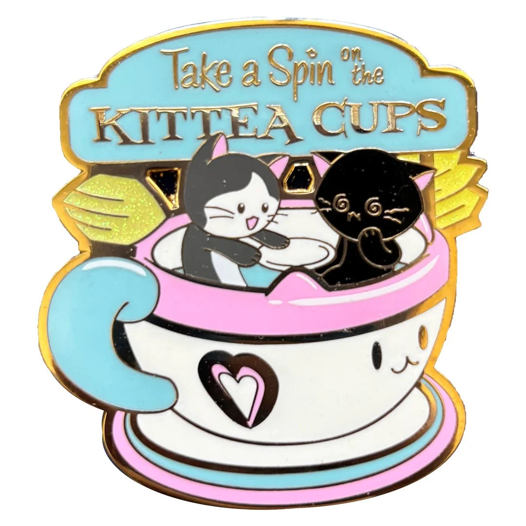 A pin of two cats in a teacup ride. Text says 'Take a spin in the Kittea Cups'.