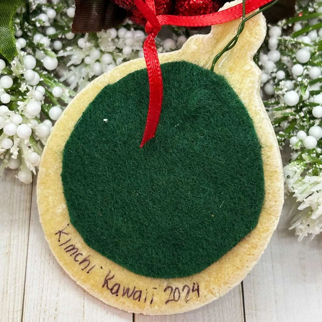 Back of round ornament with felt and 'Kimchi Kawaii, 2024'.