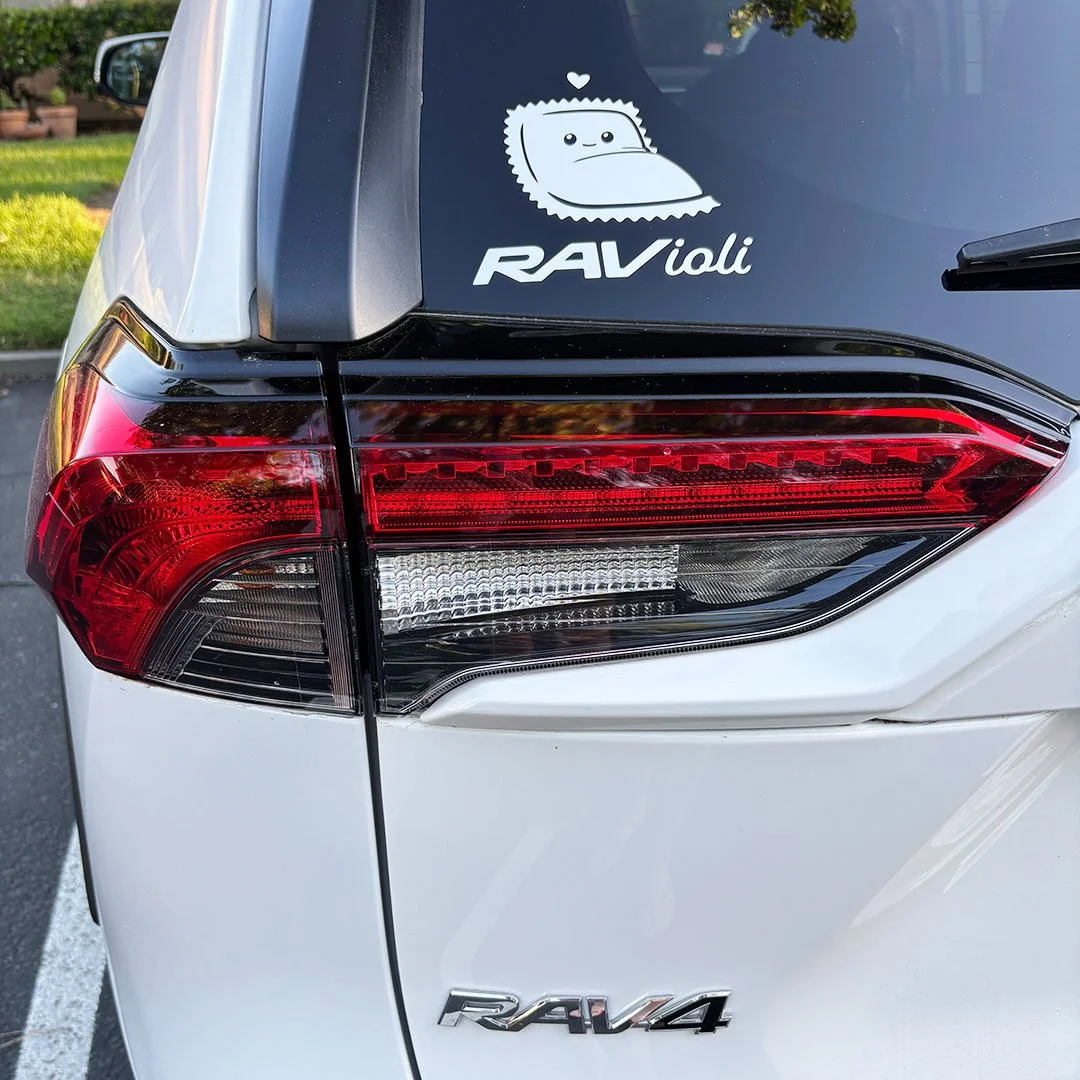 Cute ravioli sitting in a corner with the words 'ravioli' in stylized letters on the back of a car.