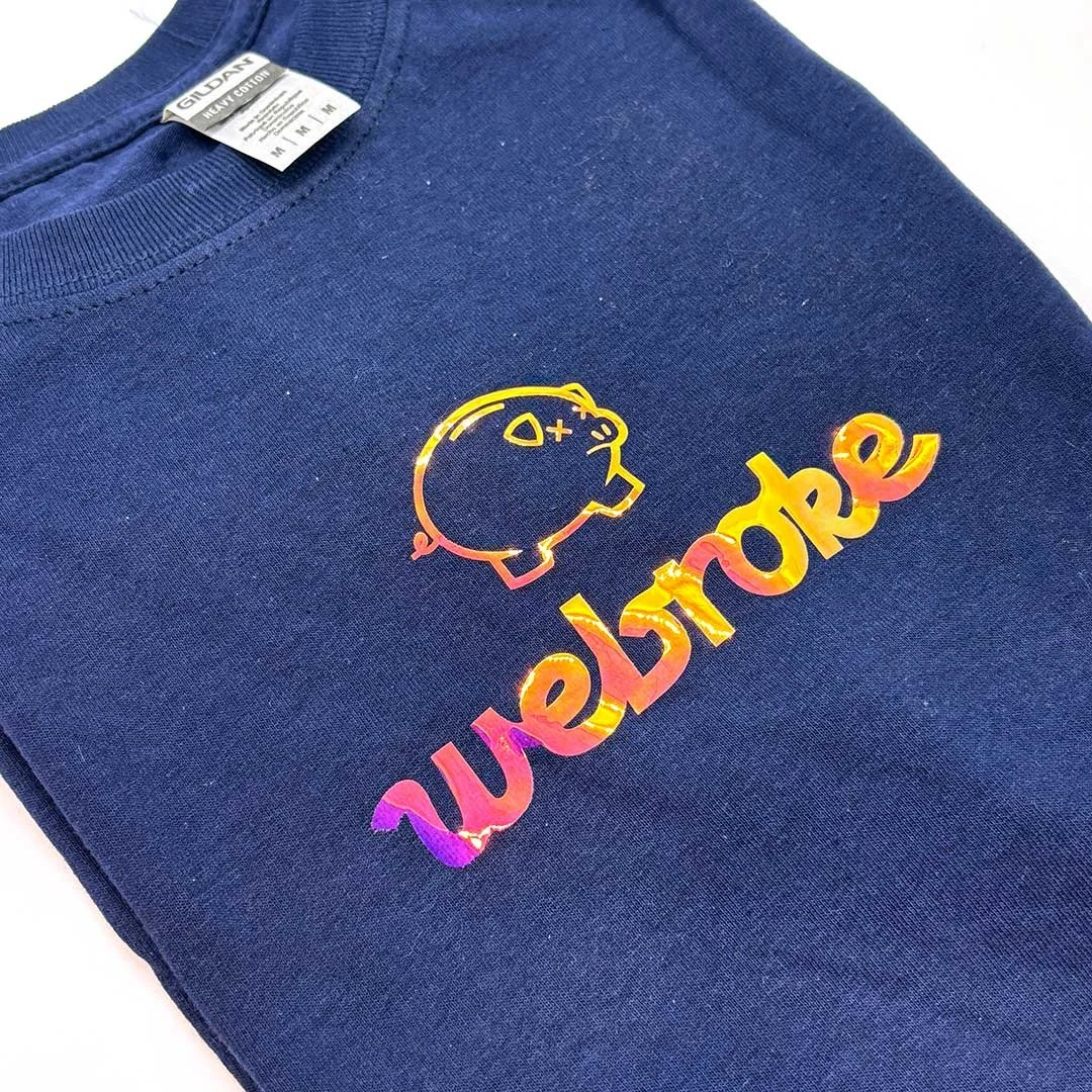 Navy shirt with a sad piggy bank and the words 'webroke, but we happy'.